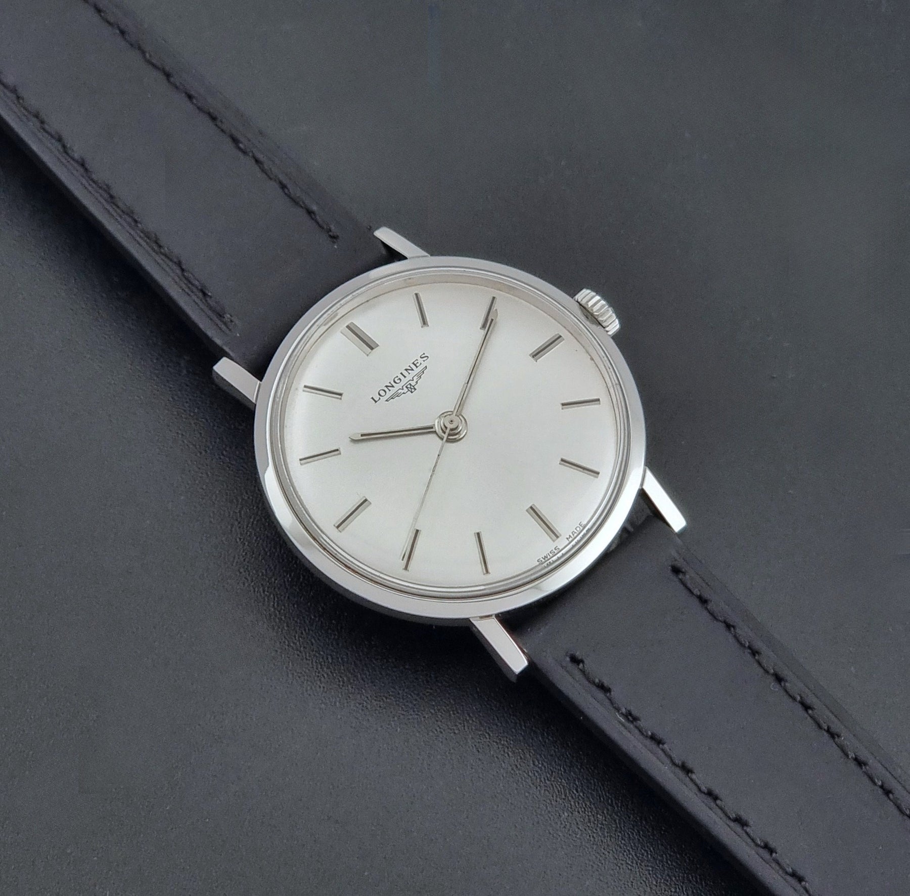 Vintage Longines 7839-5 watch with a black leather strap on a dark gray background dial