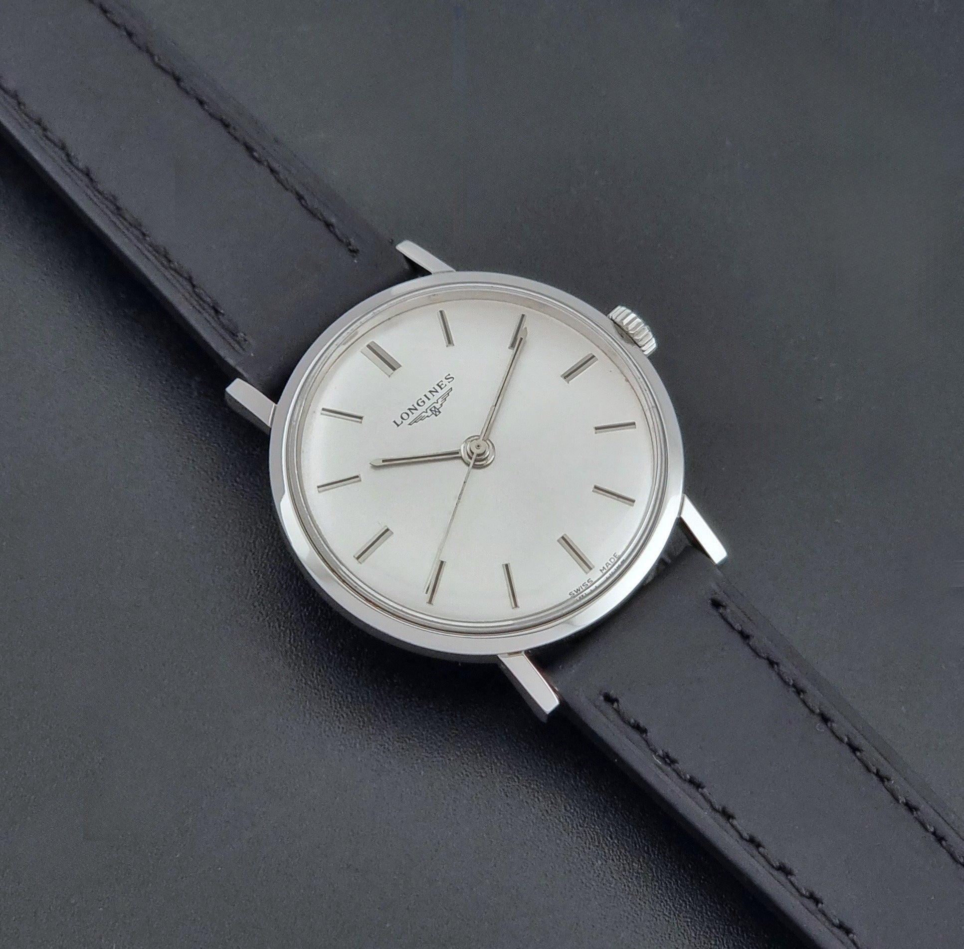 Vintage Longines 7839-5 watch with a black leather strap on a dark gray background dial