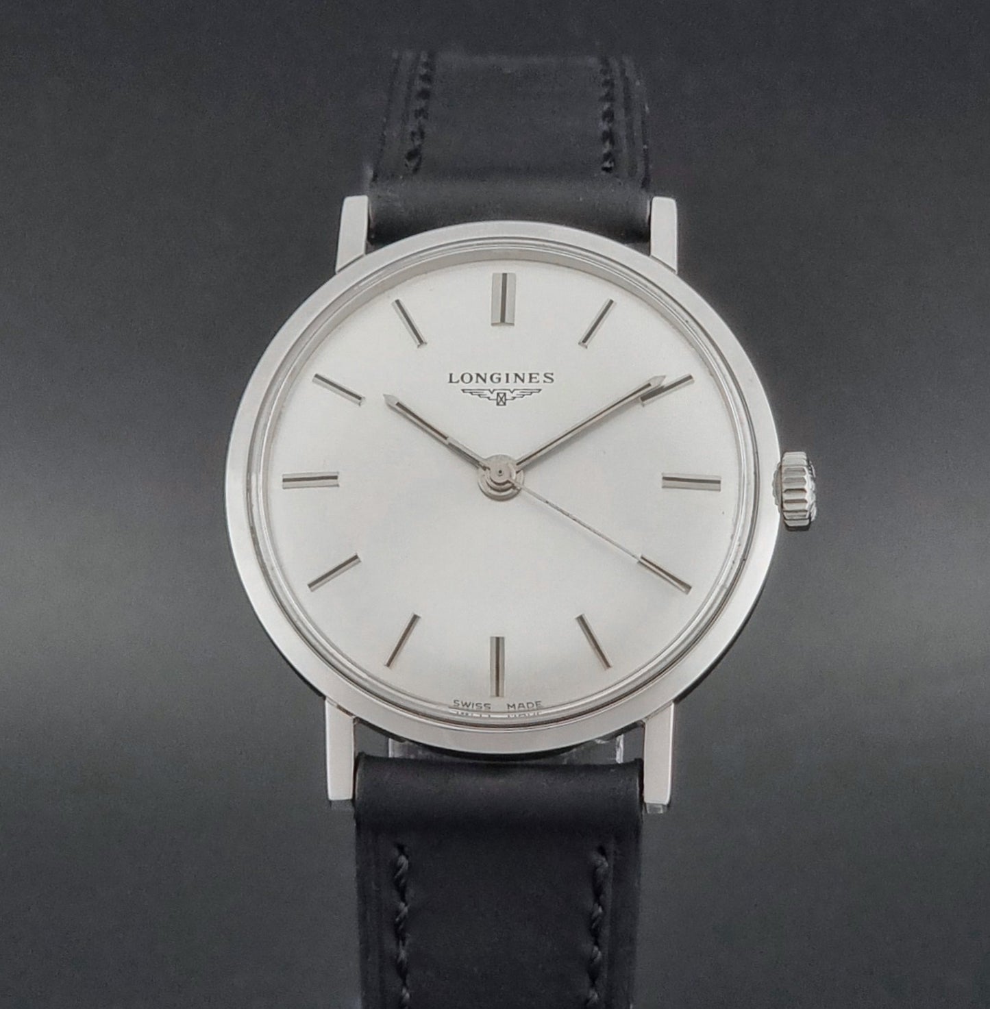 Vintage Longines 7839-5 watch with a black leather strap on a dark gray background close dial view