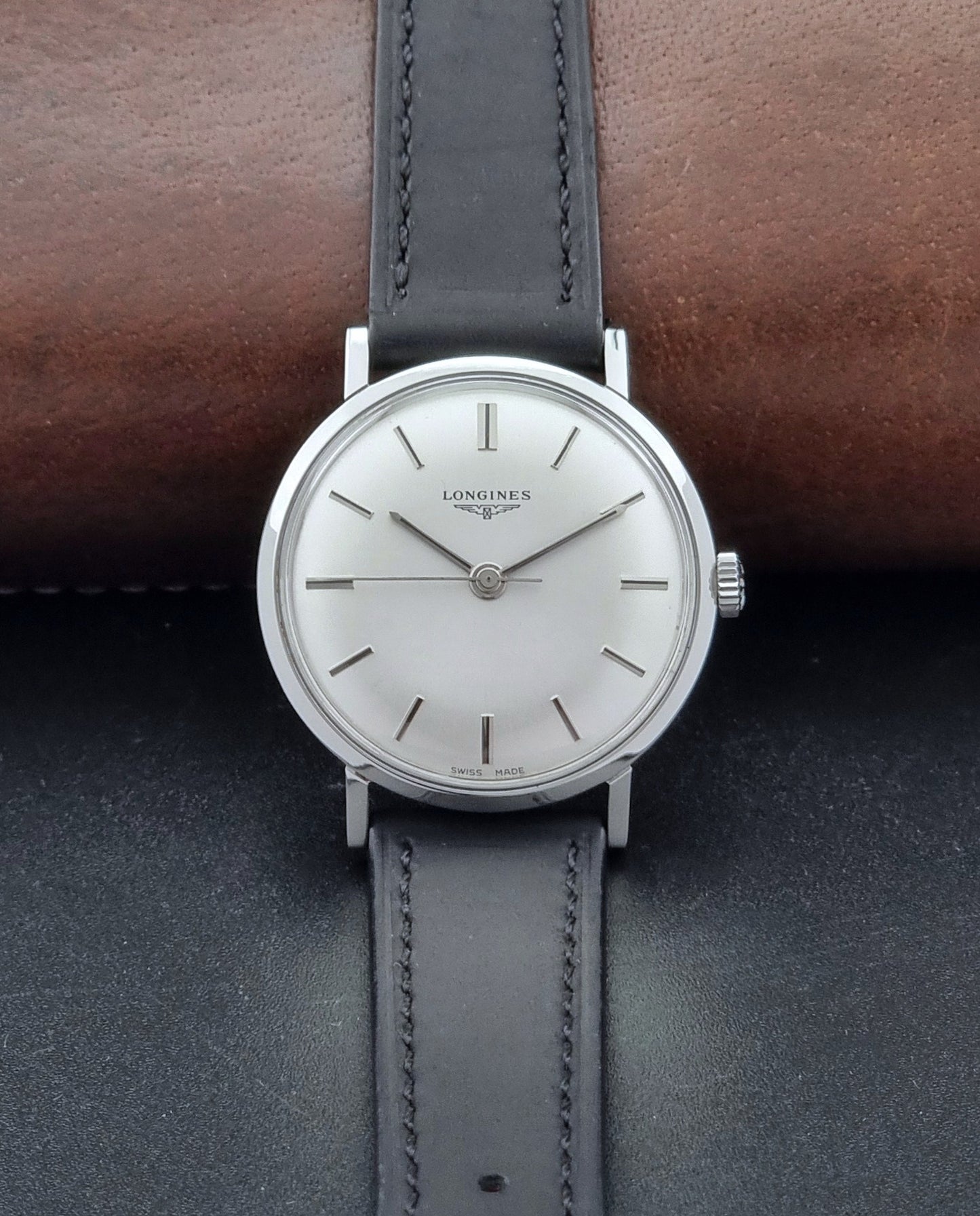 Vintage Longines 7839-5 watch with a black leather strap on a dark gray background dial view