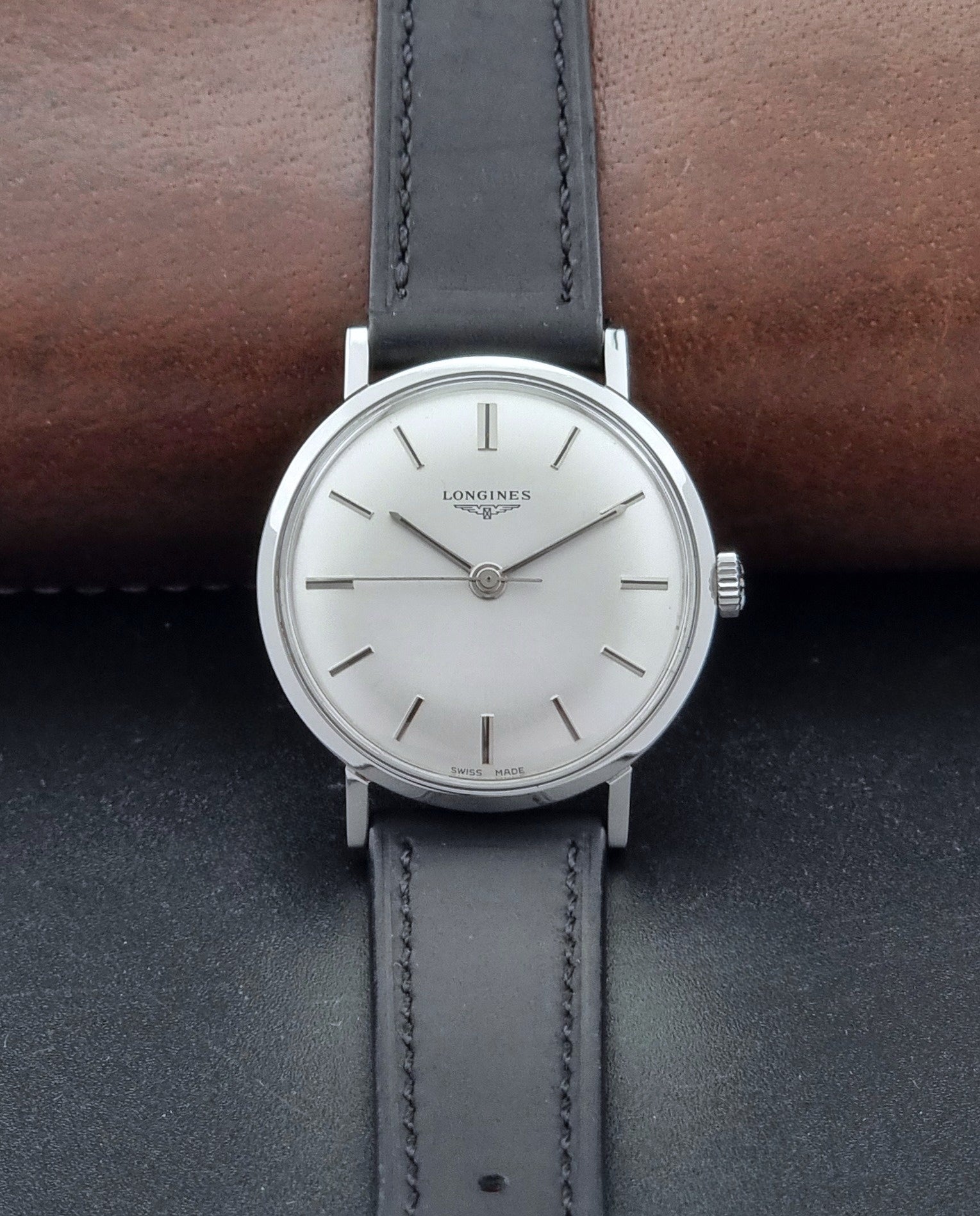 Vintage Longines 7839-5 watch with a black leather strap on a dark gray background dial view