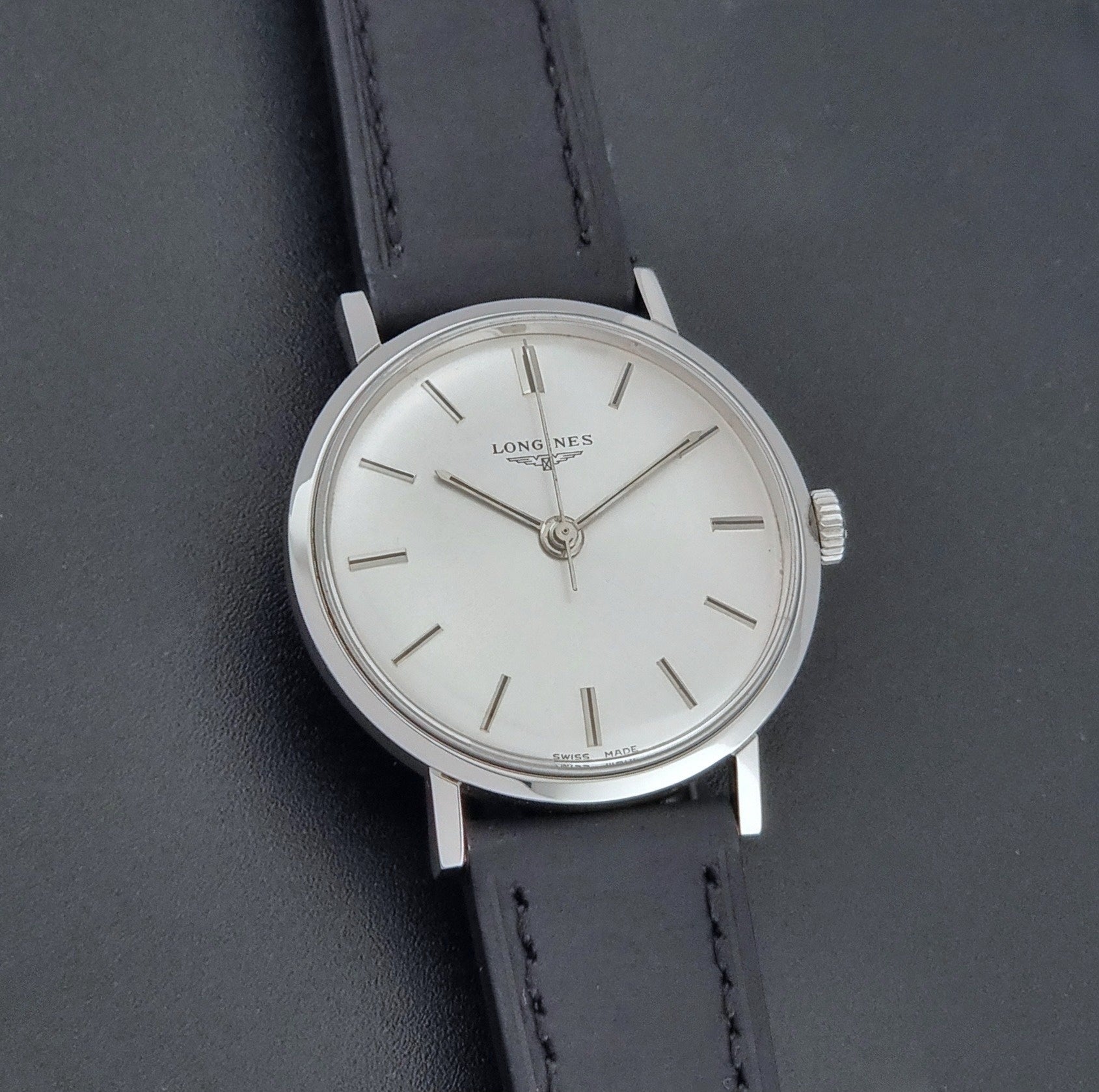 Vintage Longines 7839-5 watch with a black leather strap on a dark gray background front view