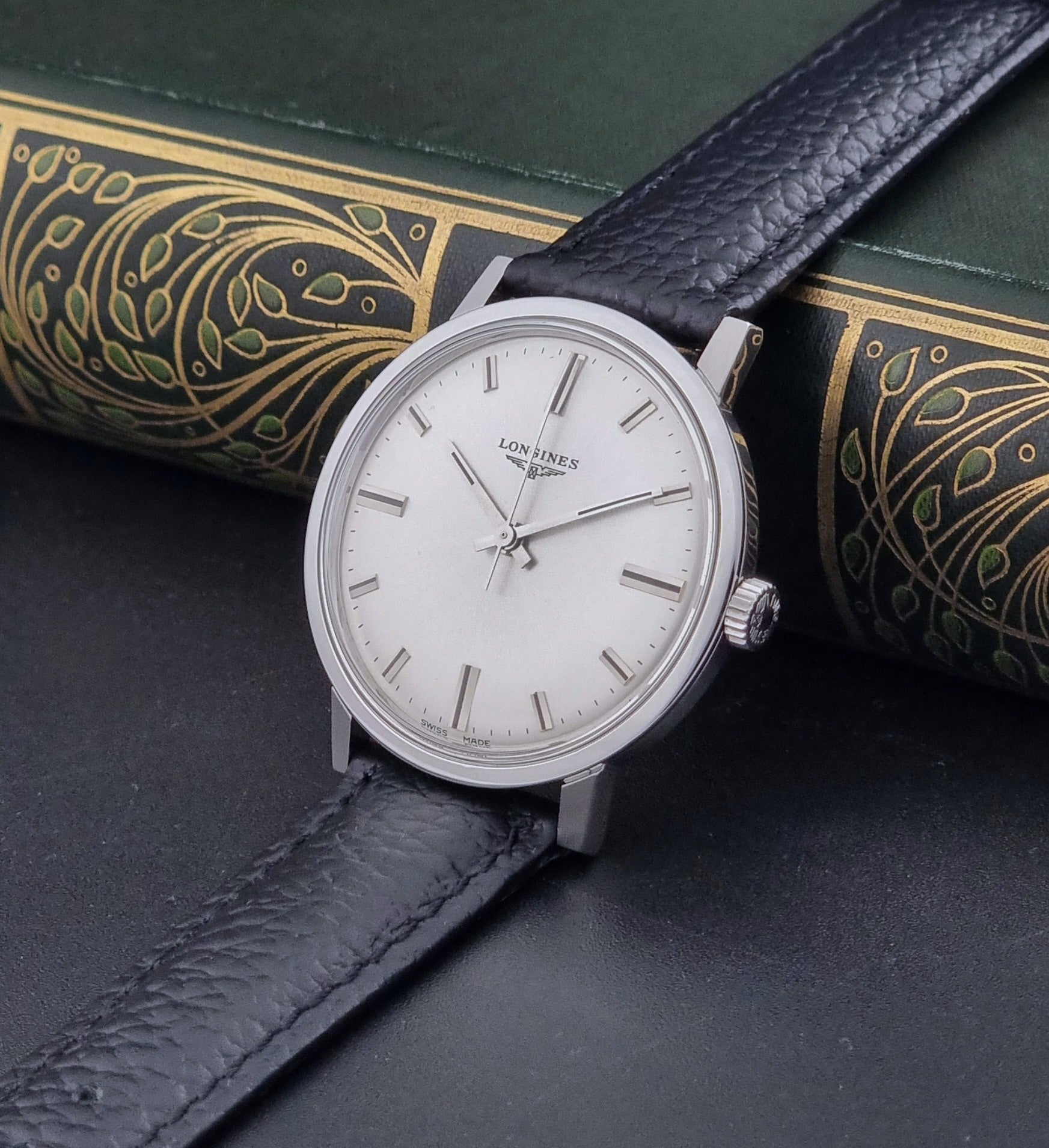 Vintage Longines 8319  Wristwatch with a black leather strap on a dark background crown view