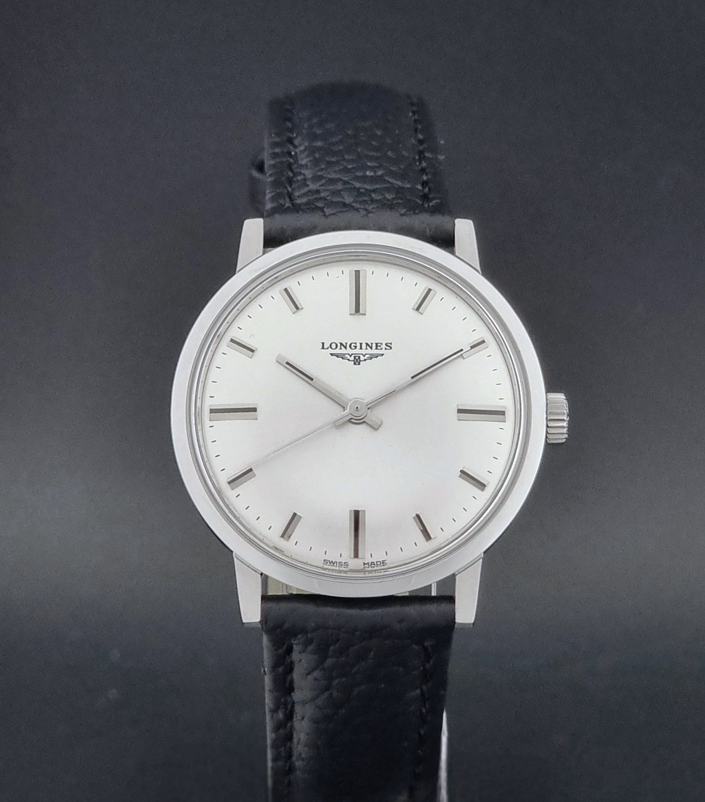 Vintage Longines 8319  Wristwatch with a black leather strap on a dark background close dial view