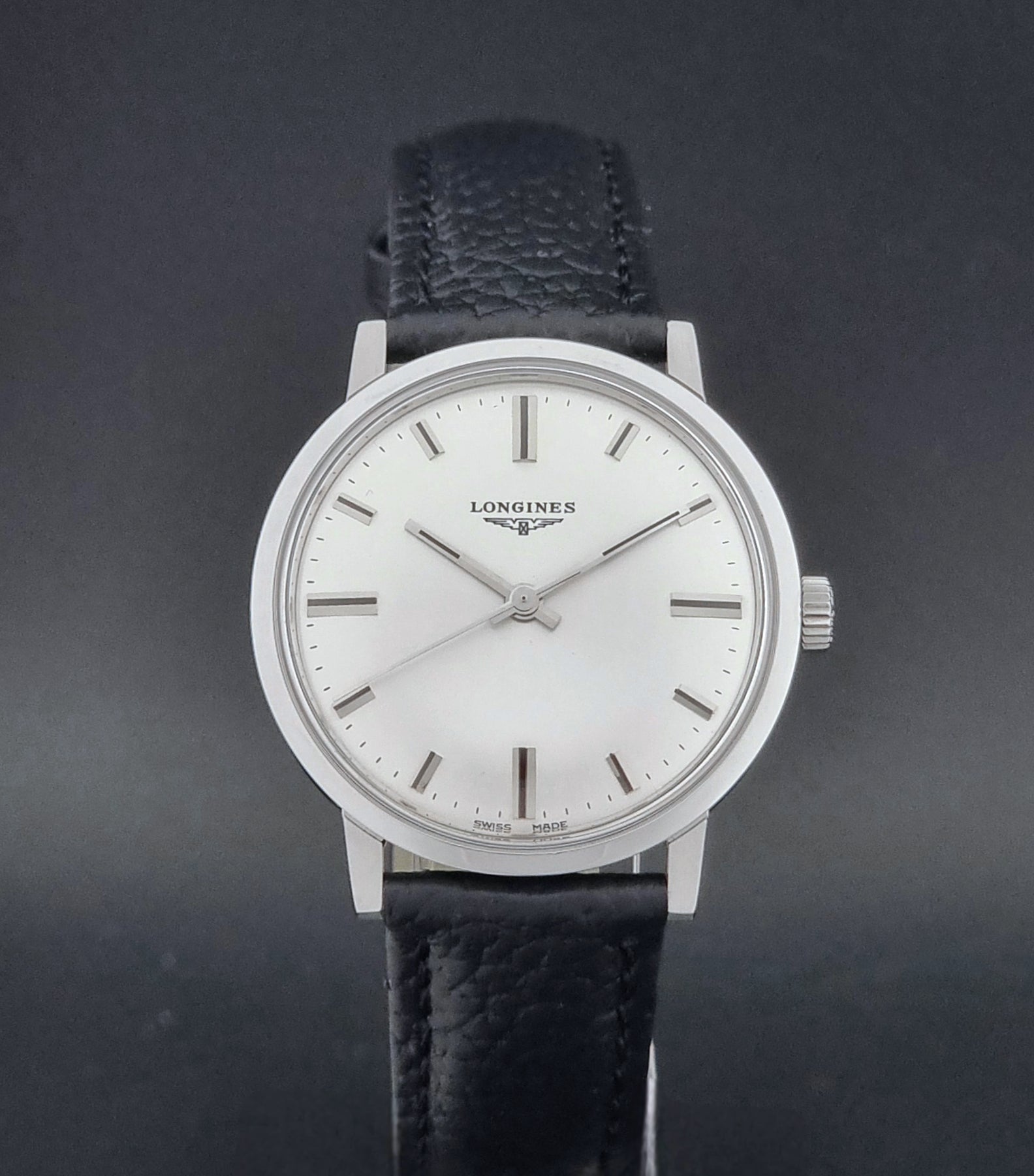 Vintage Longines 8319  Wristwatch with a black leather strap on a dark background close dial view