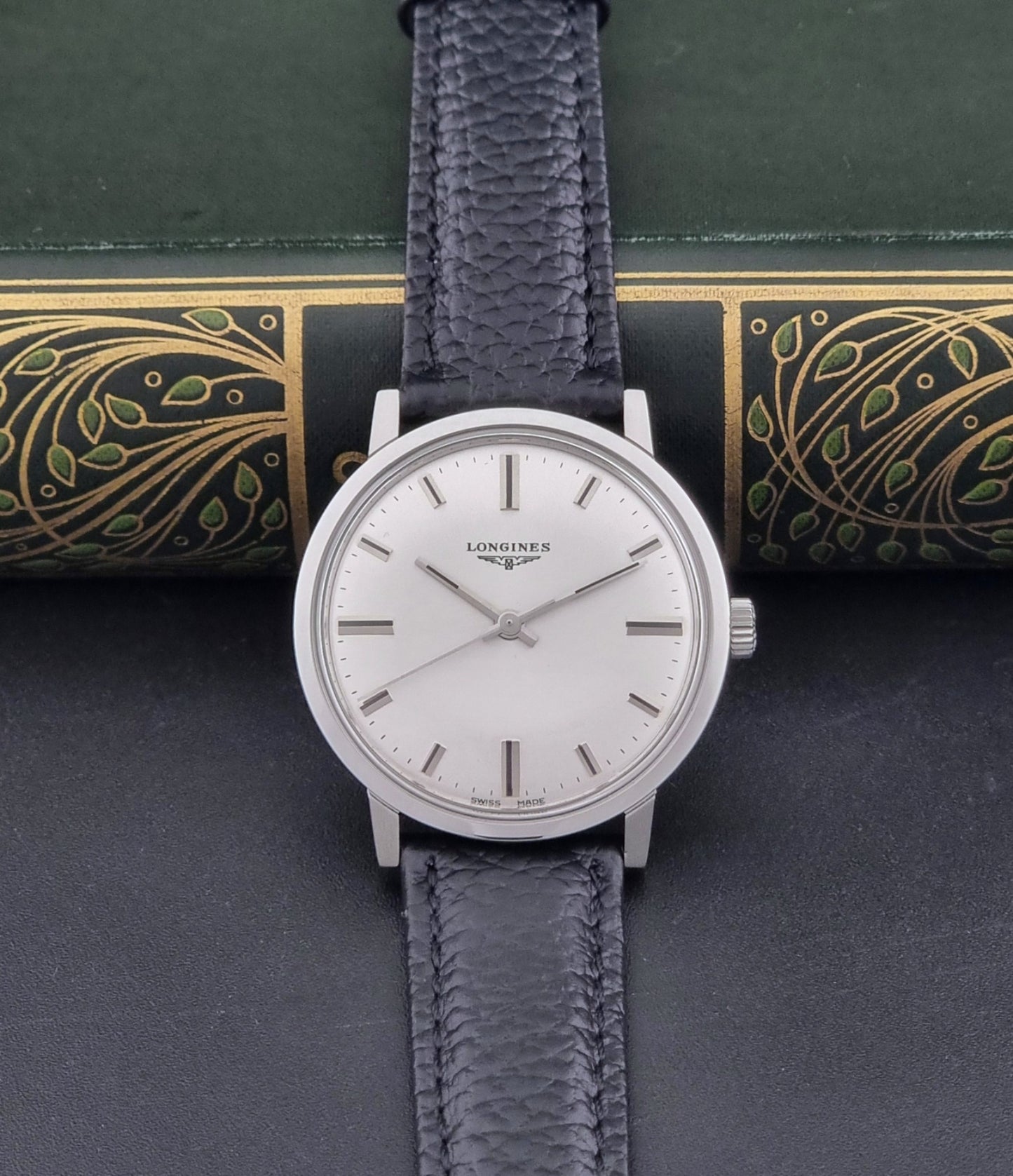 Vintage Longines 8319  Wristwatch with a black leather strap on a dark background dial view