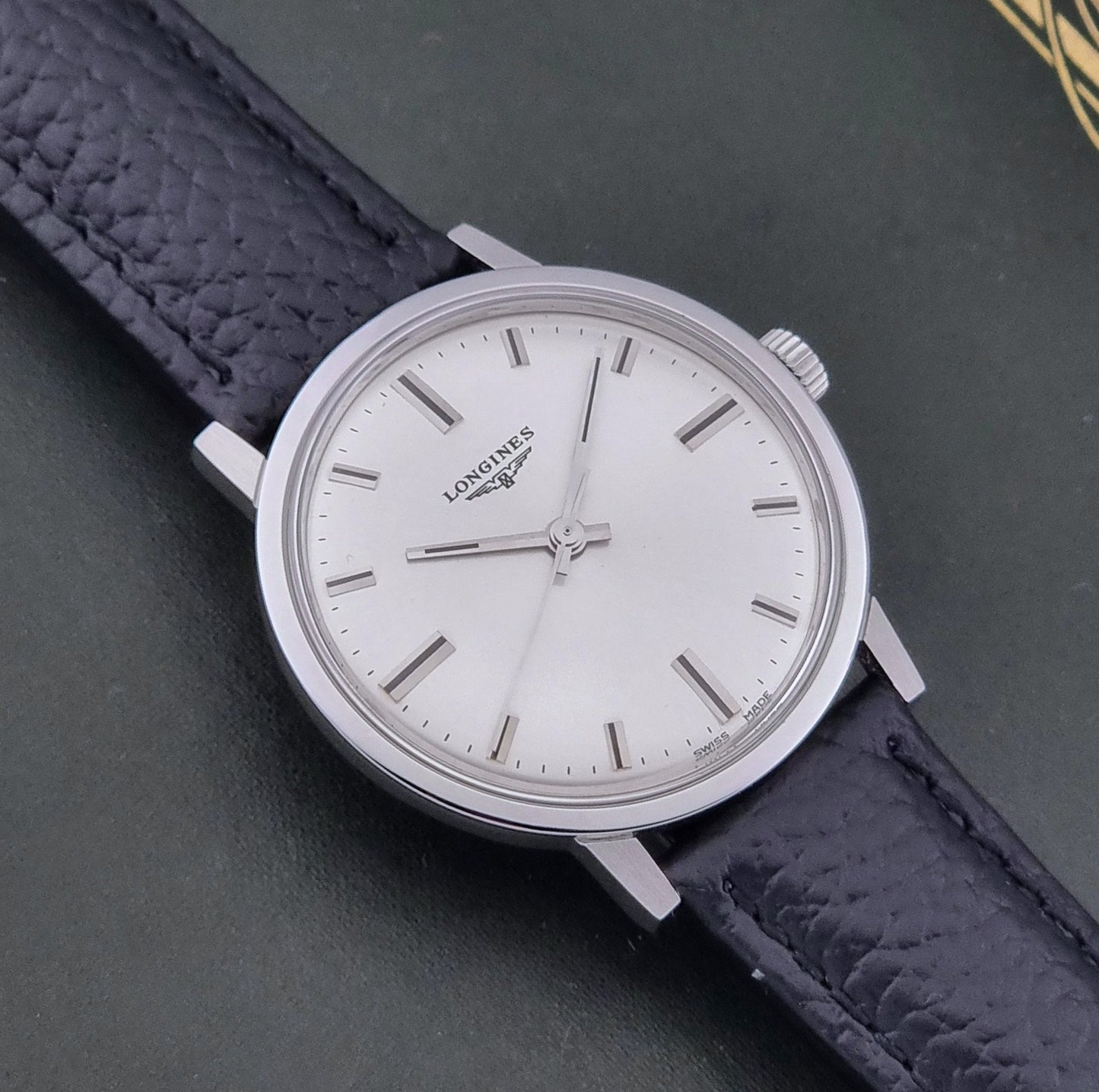 Vintage Longines 8319  Wristwatch with a black leather strap on a dark background close up dial view