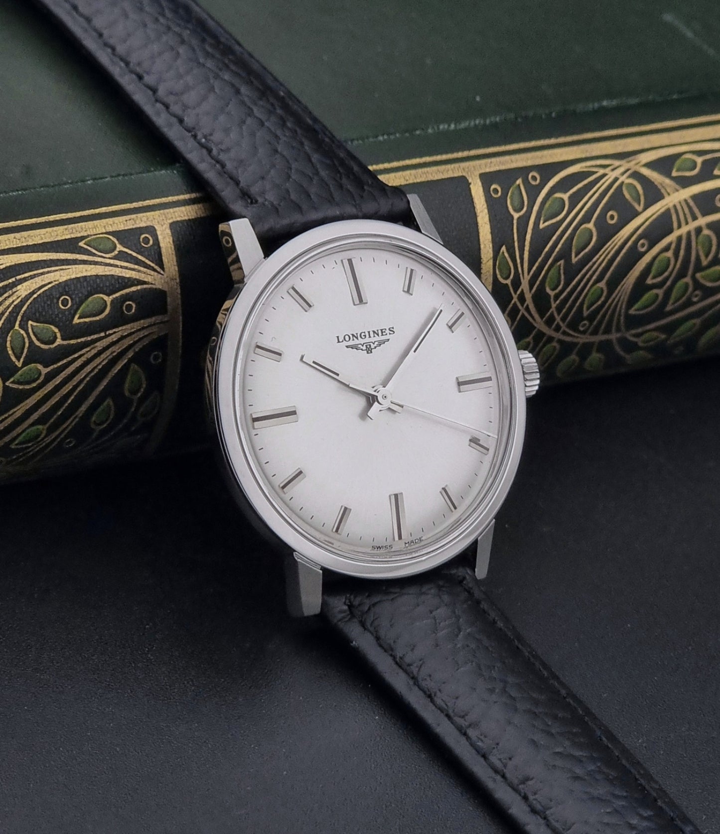 Vintage Longines 8319  Wristwatch with a black leather strap on a dark background side view