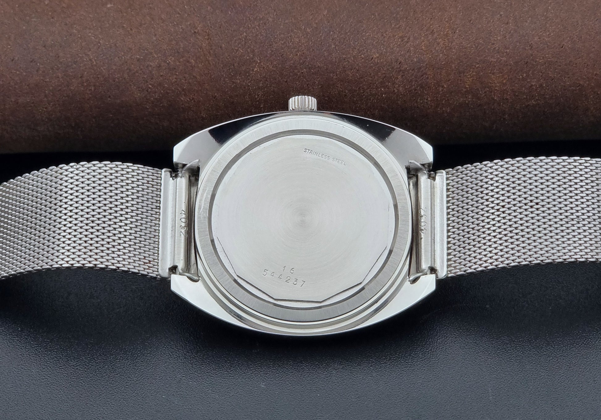 Vintage Longines Admiral Hi frequency Wristwatch 2304-2 with a mesh band on a dark gray background case back view