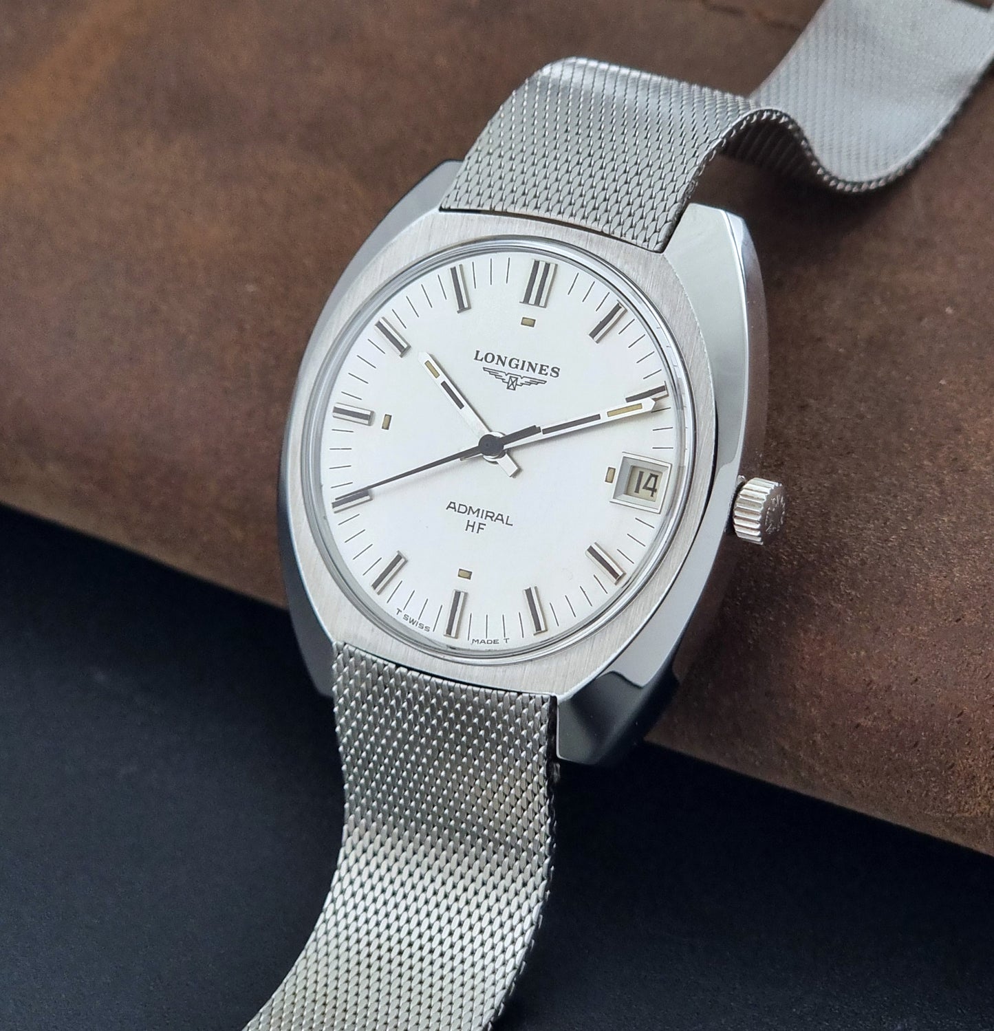 Vintage Longines Admiral Hi frequency Wristwatch 2304-2 with a mesh band on a dark gray background crown view