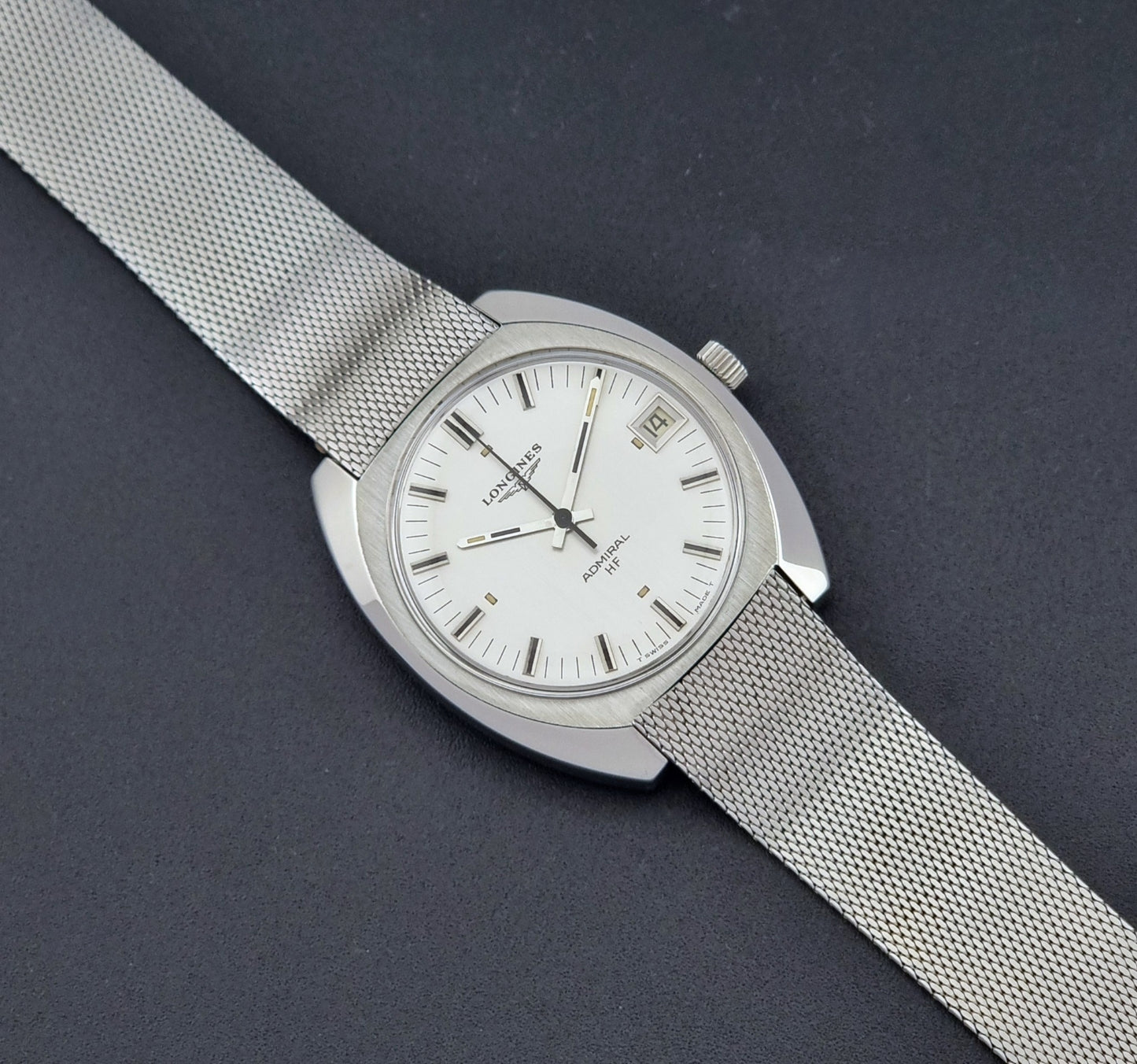 Vintage Longines Admiral Hi frequency Wristwatch 2304-2 with a mesh band on a dark gray background close up dial view