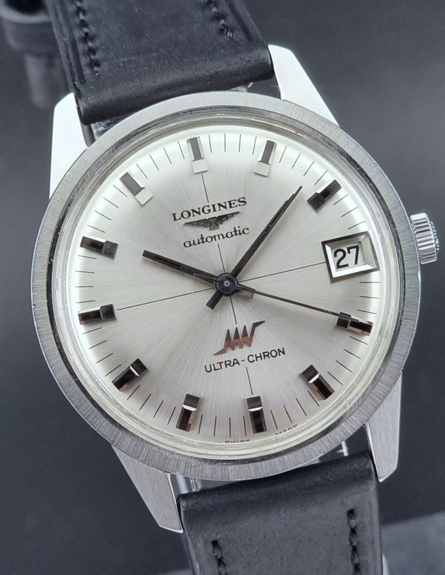 Longines Ultra-Chron watch with black leather strap on a dark background