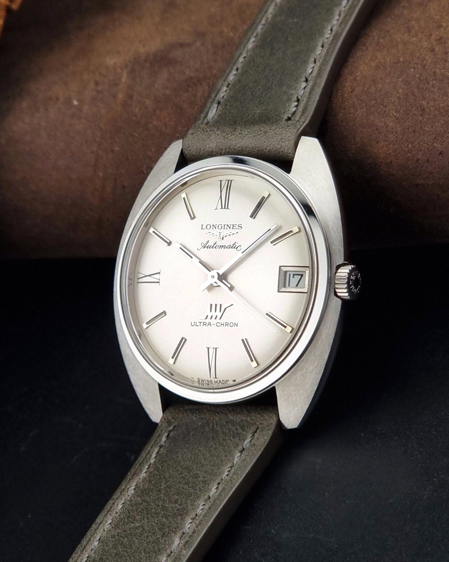 Vintage Longines wristwatch ULTRA-CHRON 8317 with a grey leather strap on a dark background crown view