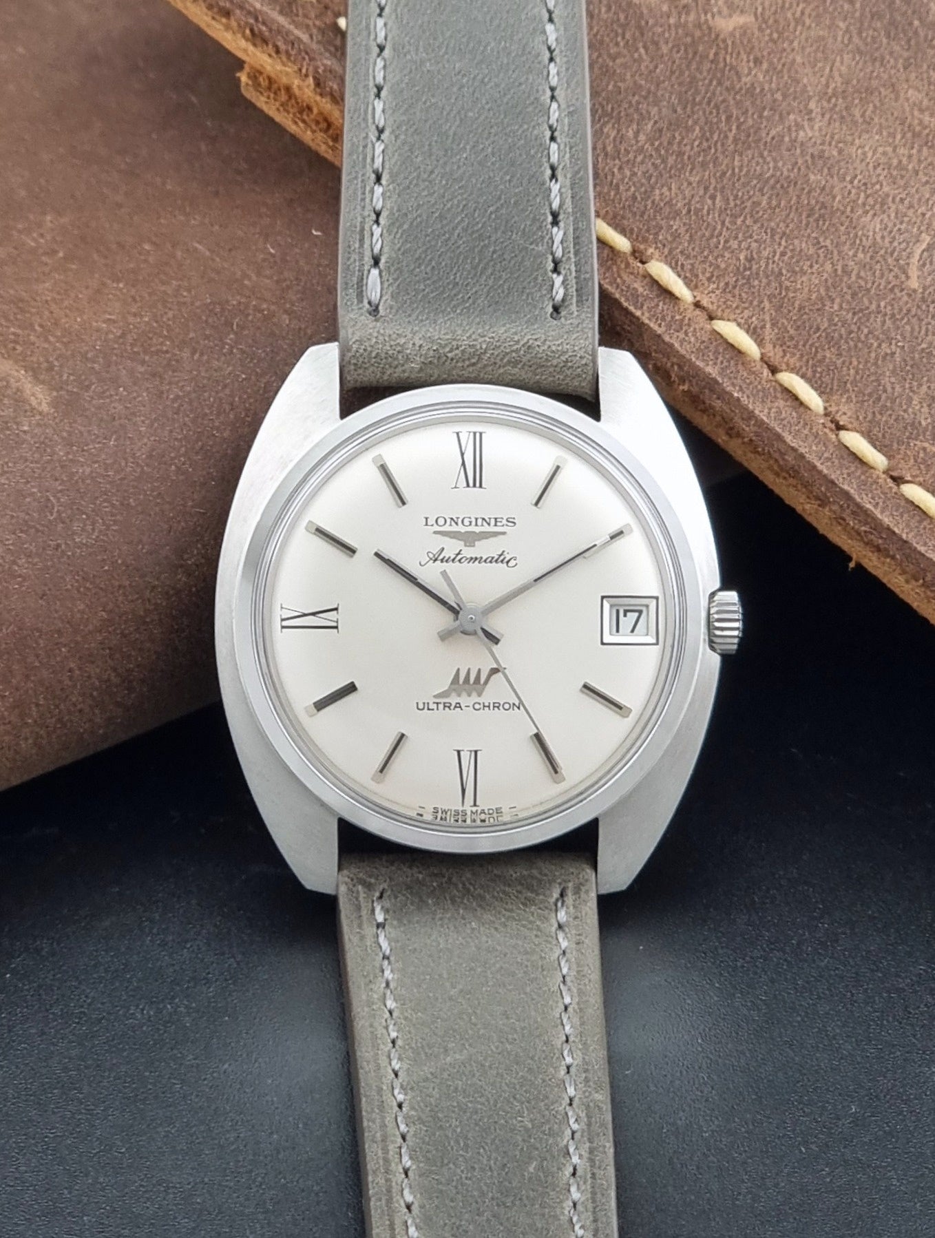 Vintage Longines wristwatch ULTRA-CHRON 8317 with a grey leather strap on a dark background dial view