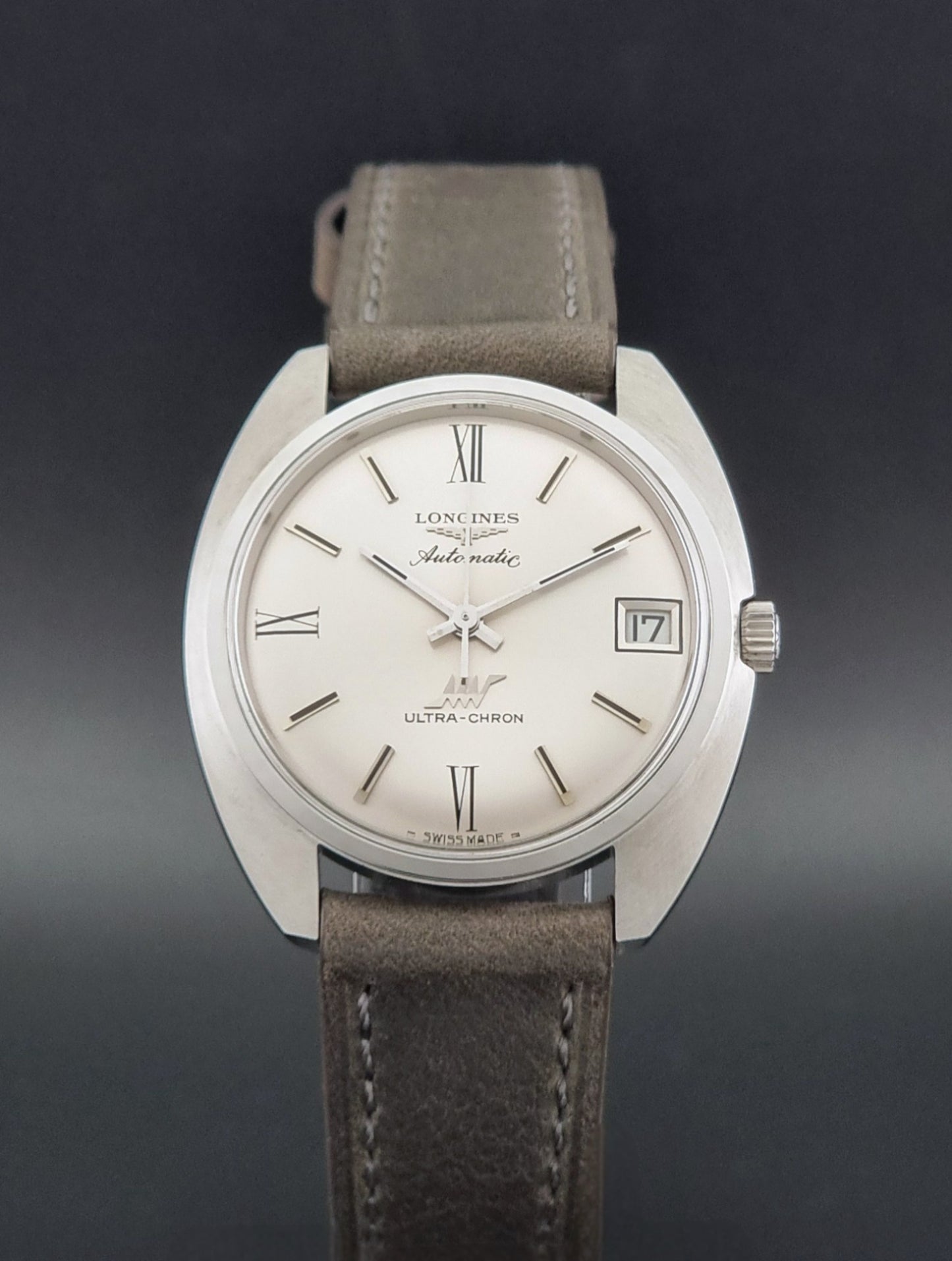Vintage Longines wristwatch ULTRA-CHRON 8317 with a grey leather strap on a dark background close dial view