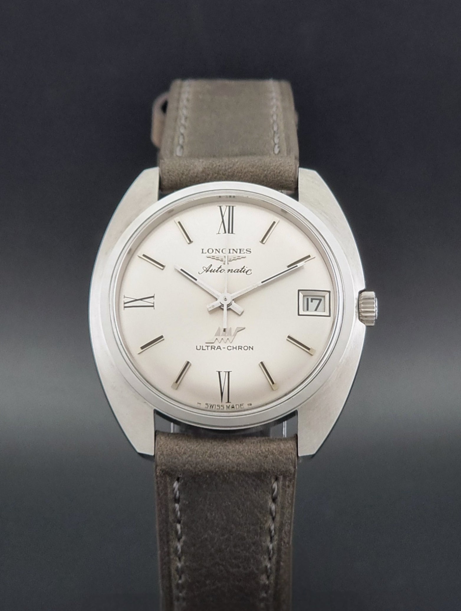 Vintage Longines wristwatch ULTRA-CHRON 8317 with a grey leather strap on a dark background close dial view