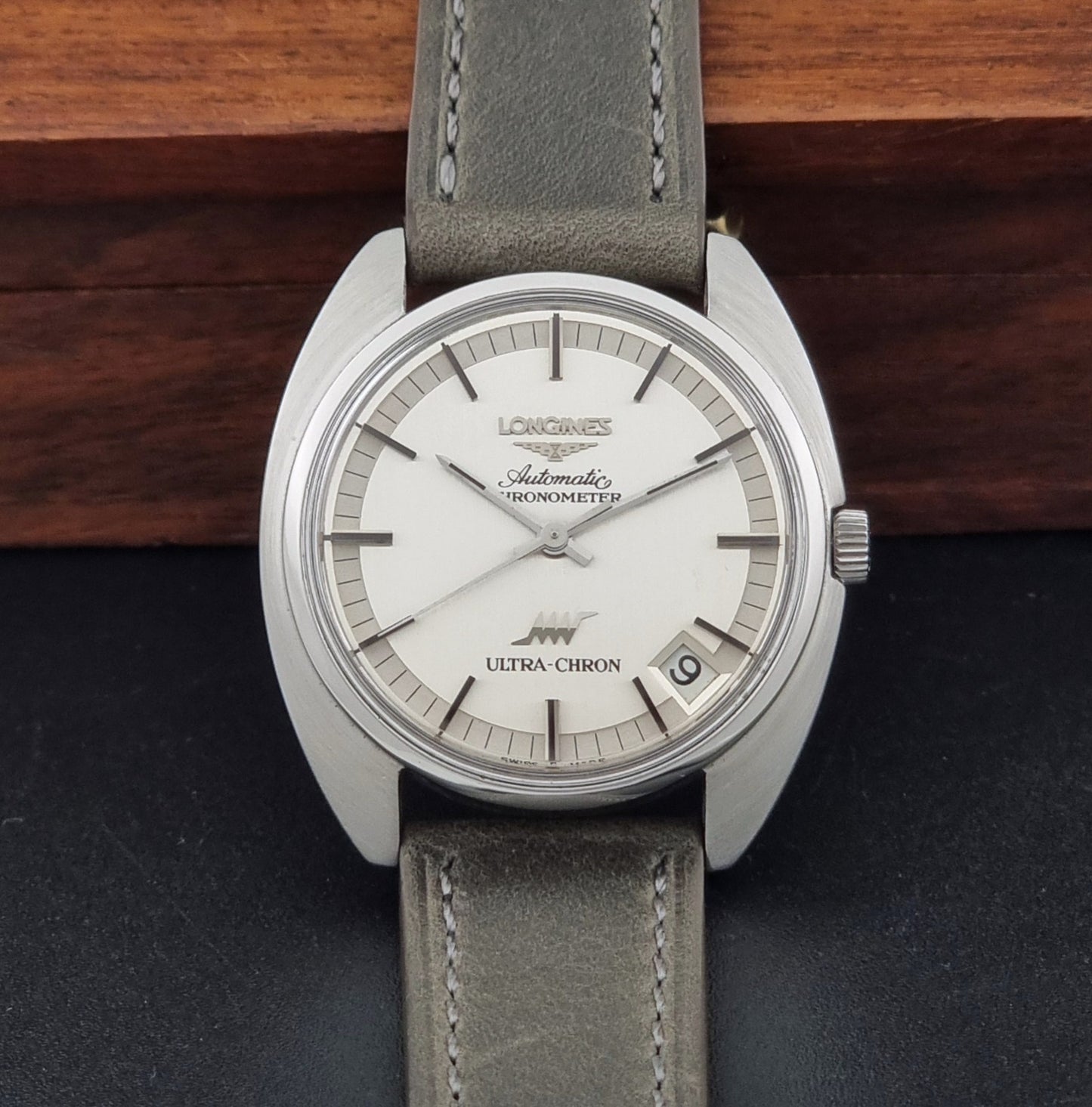 Vintage Longines ULTRA-CHRON 8353-1 watch with gray leather strap and silver case on a dark background dial view