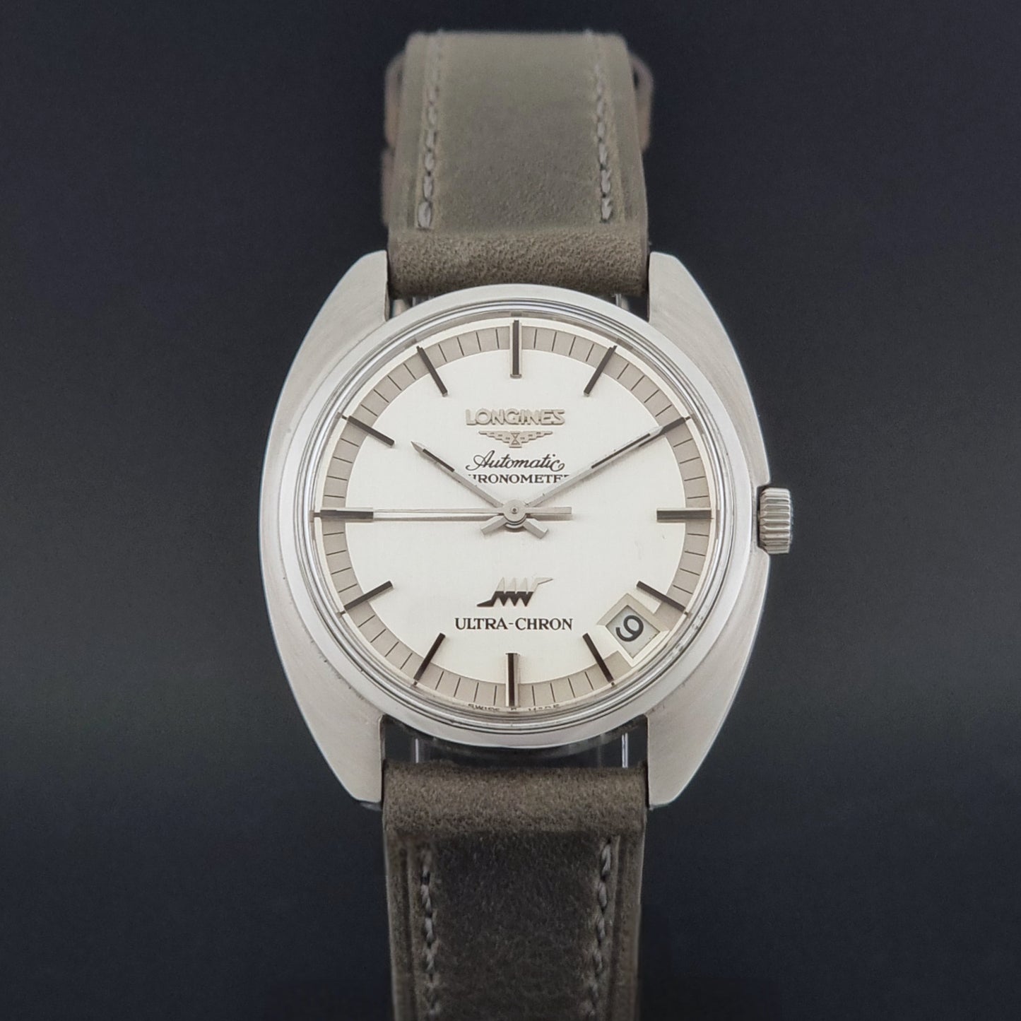Vintage Longines ULTRA-CHRON 8353-1 watch with gray leather strap and silver case on a dark background close dial view