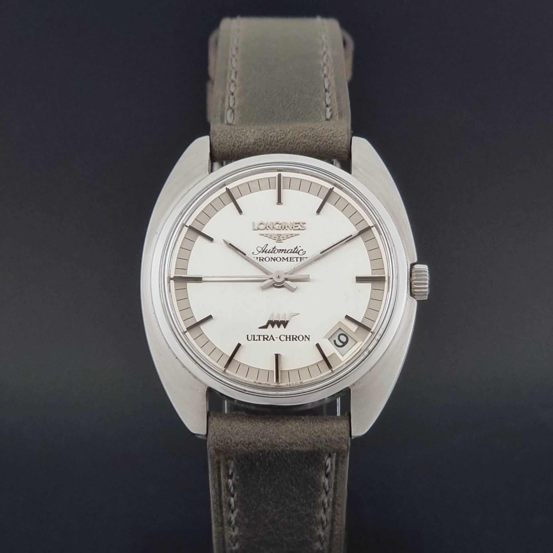 Vintage Longines ULTRA-CHRON 8353-1 watch with gray leather strap and silver case on a dark background close dial view