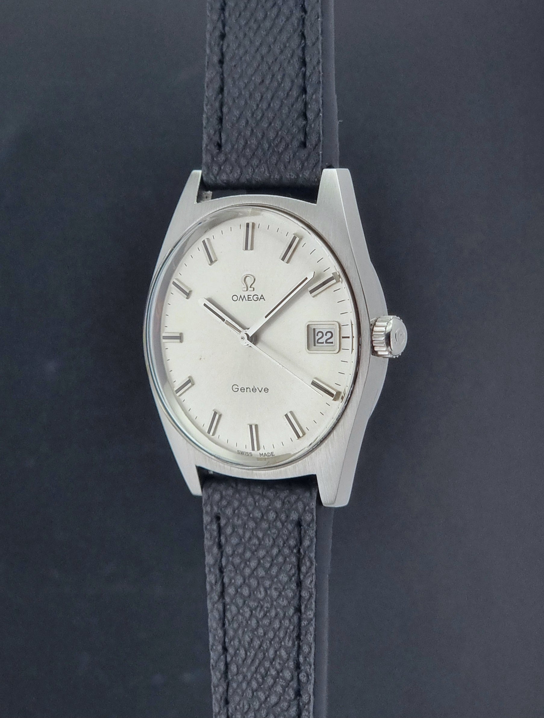 Vintage Omega Geneve 136.041 watch with black strap on a dark background crown profile view