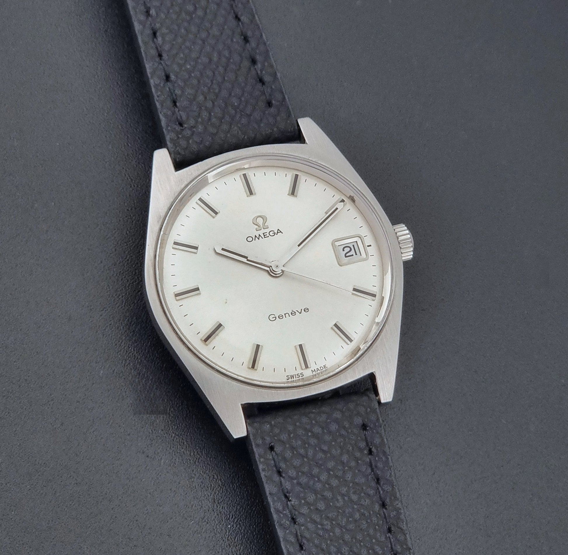 Vintage Omega Geneve 136.041 watch with black strap on a dark background front view