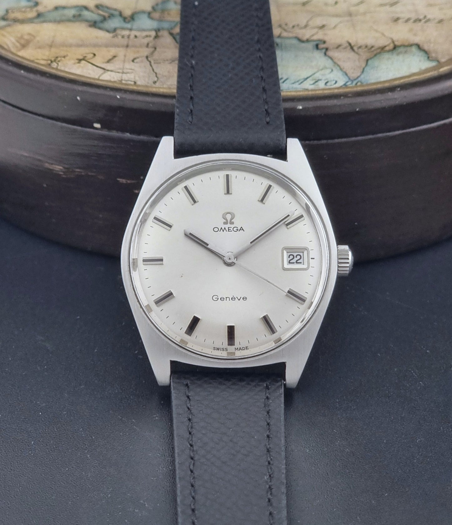 Vintage Omega Geneve 136.041 watch with black strap on a dark background dial view