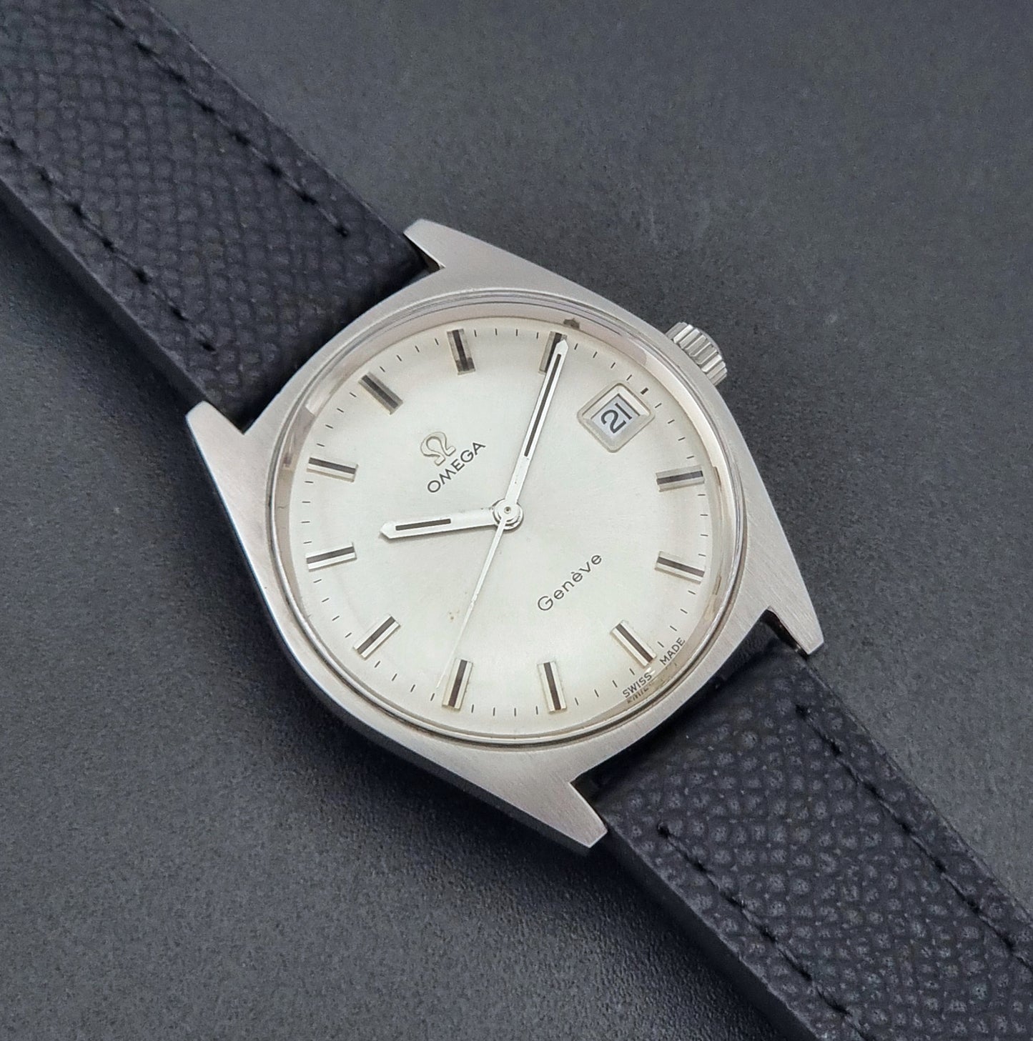 Vintage Omega Geneve 136.041 watch with black strap on a dark background close dial view