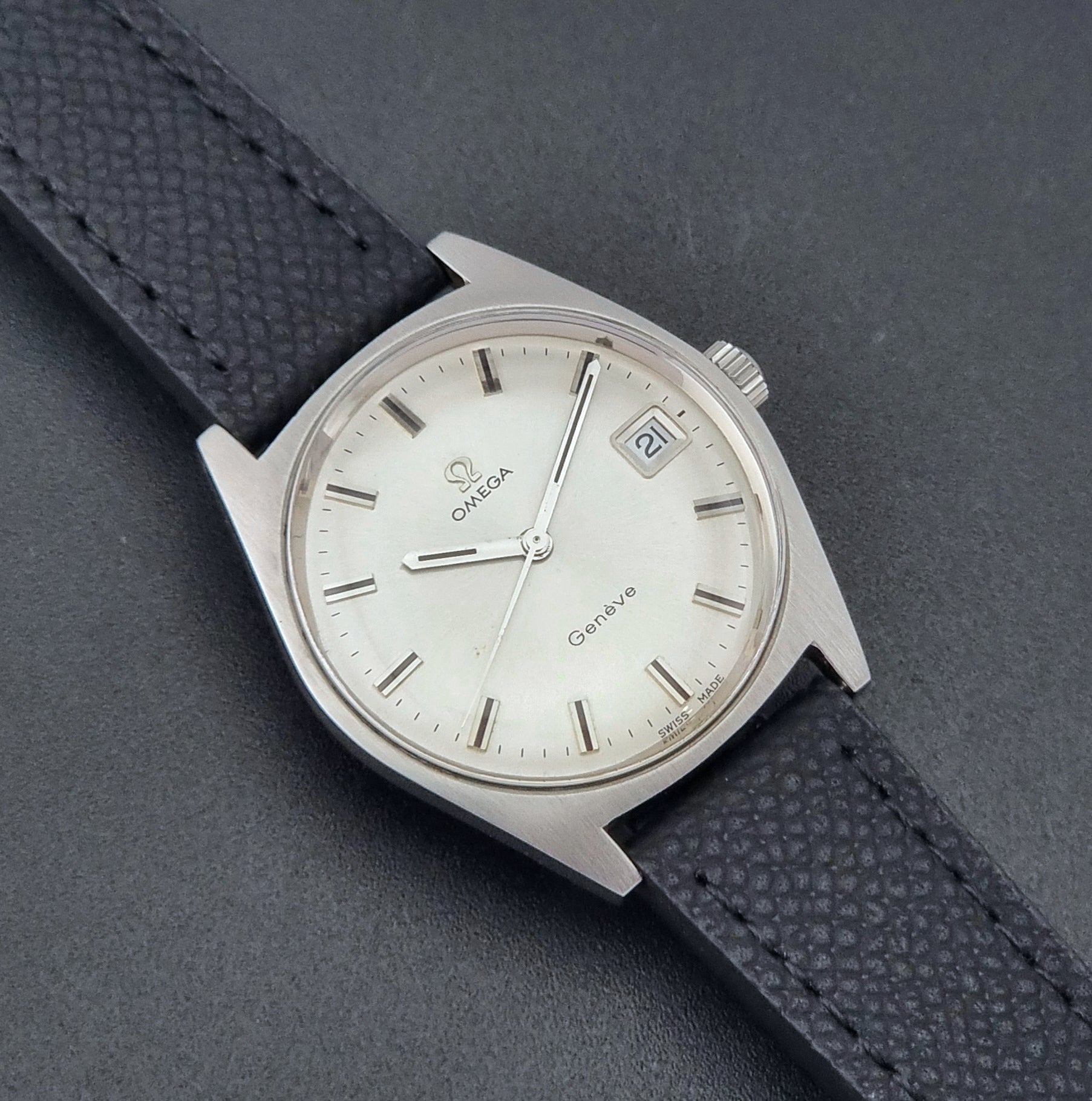 Vintage Omega Geneve 136.041 watch with black strap on a dark background close dial view