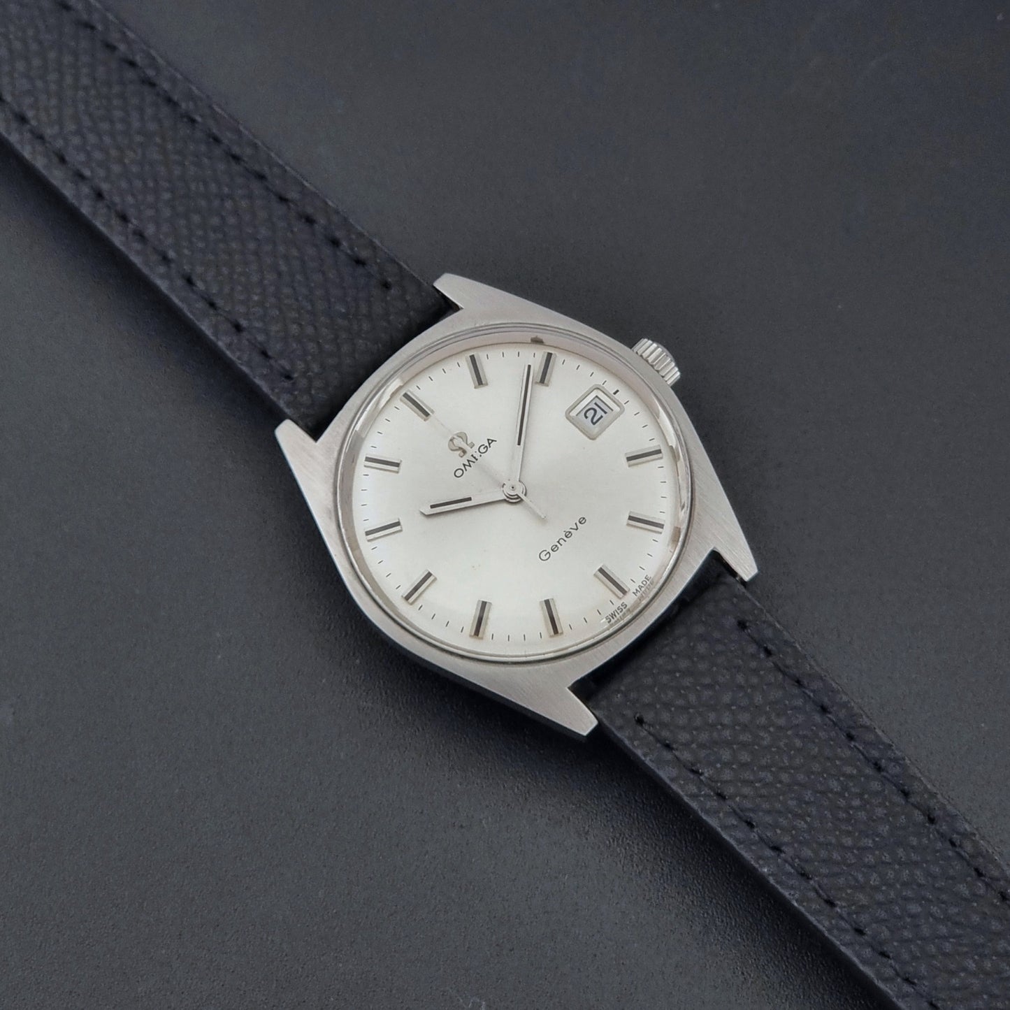 Vintage Omega Geneve 136.041 watch with black strap on a dark background dial
