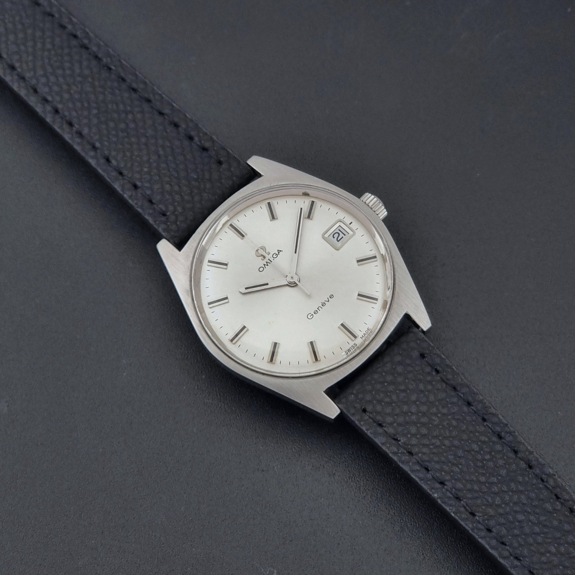 Vintage Omega Geneve 136.041 watch with black strap on a dark background dial
