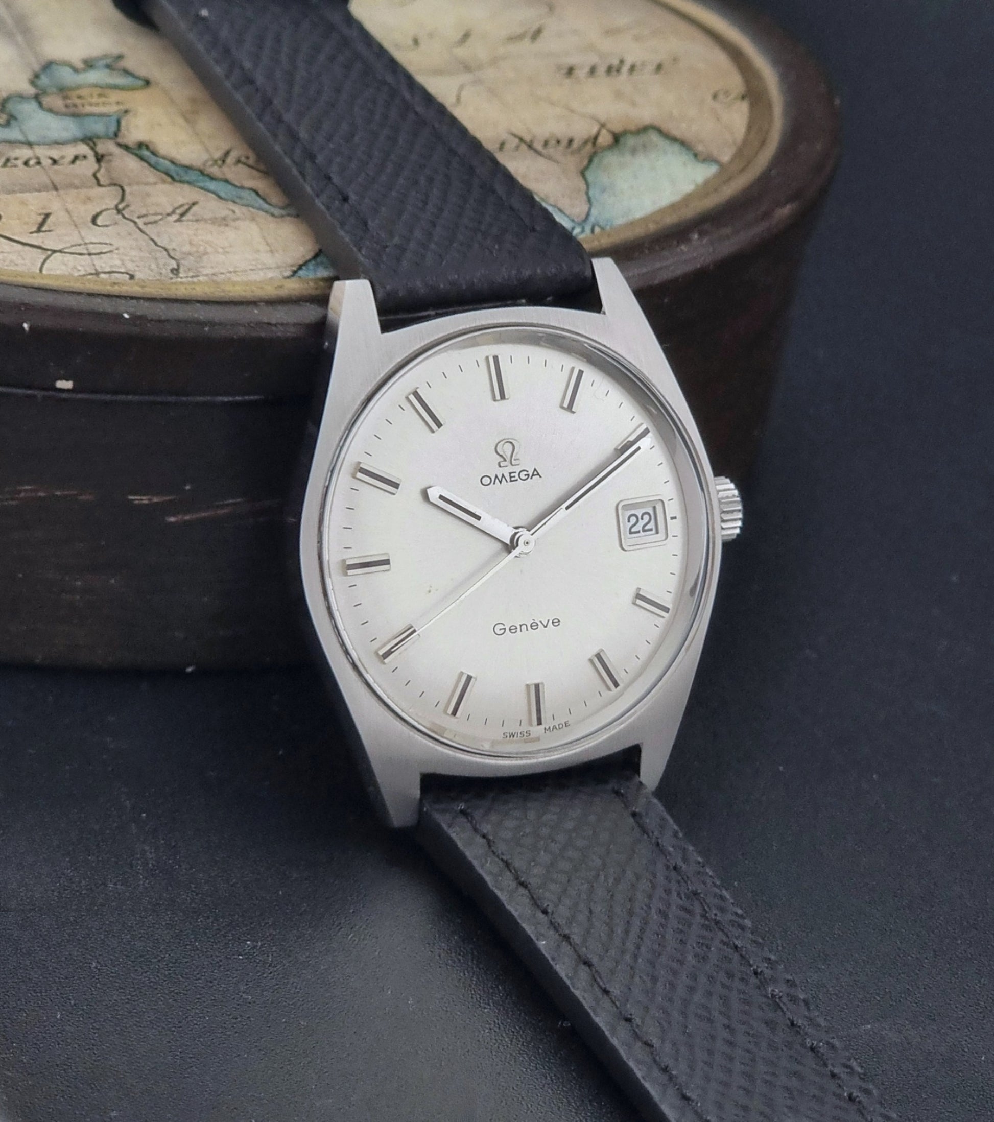Vintage Omega Geneve 136.041 watch with black strap on a dark background side view