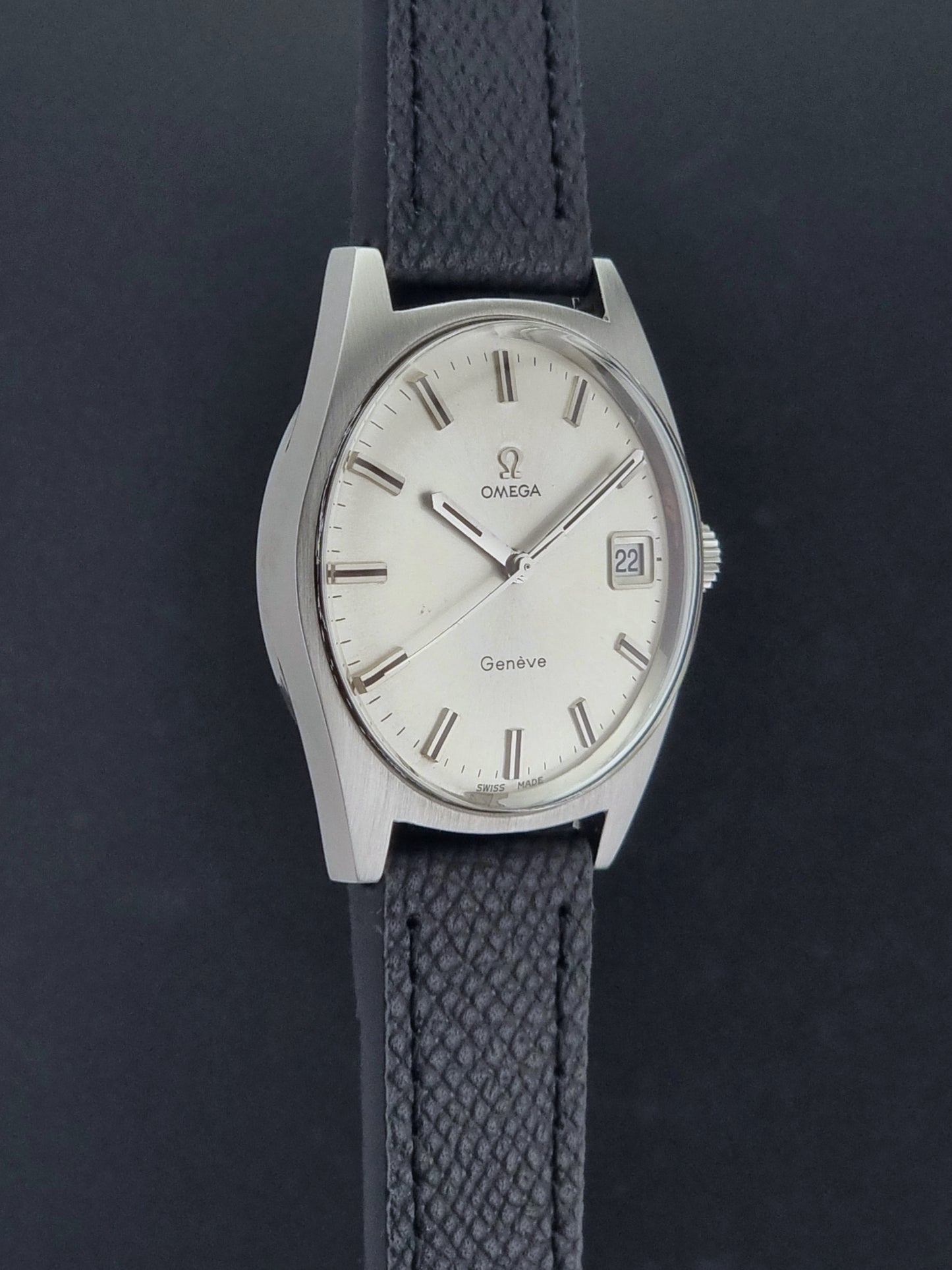 Vintage Omega Geneve 136.041 watch with black strap on a dark background side profile view