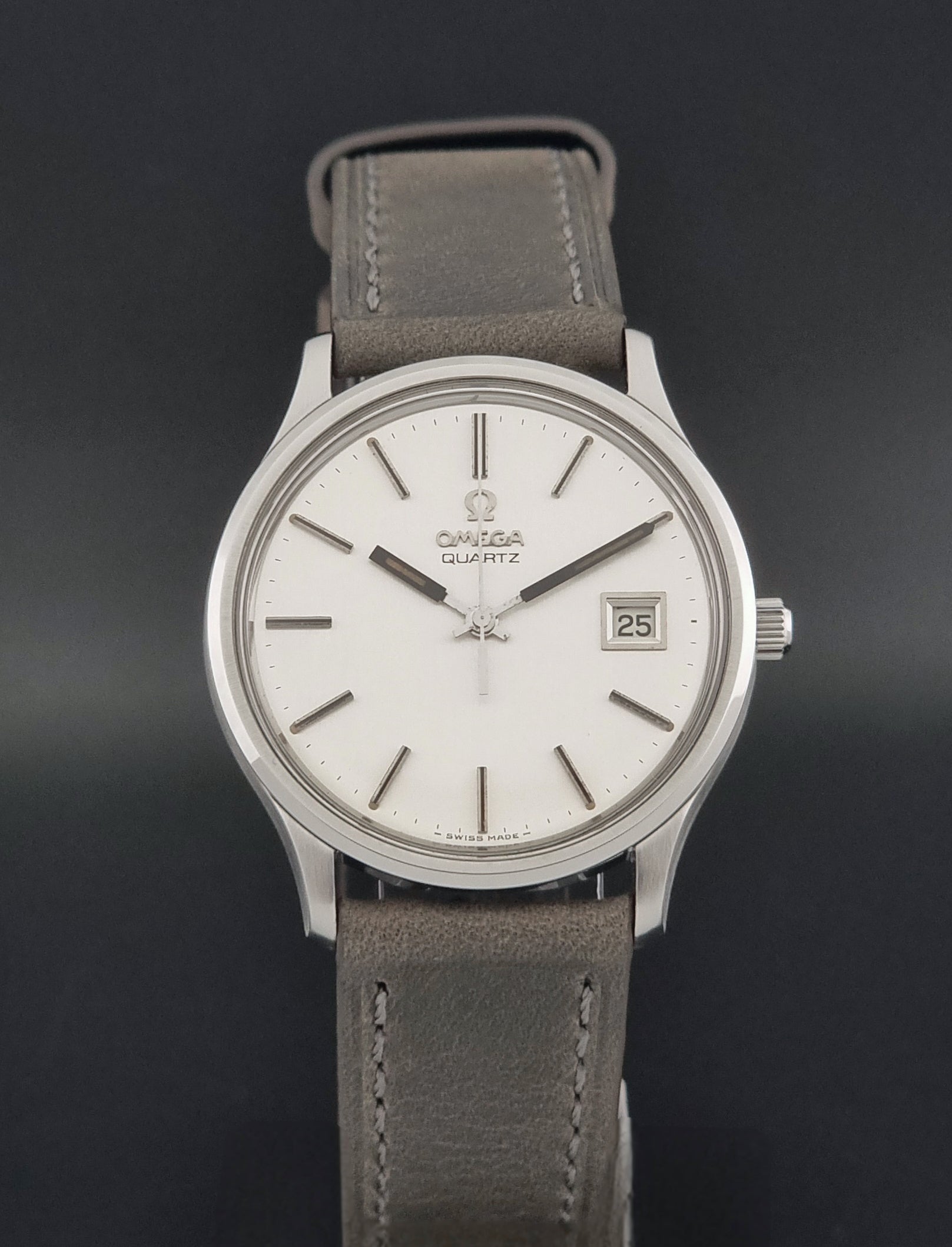 Vintage Omega Quartz Wristwatch 196.0071 with a grey strap on a dark background close dial view
