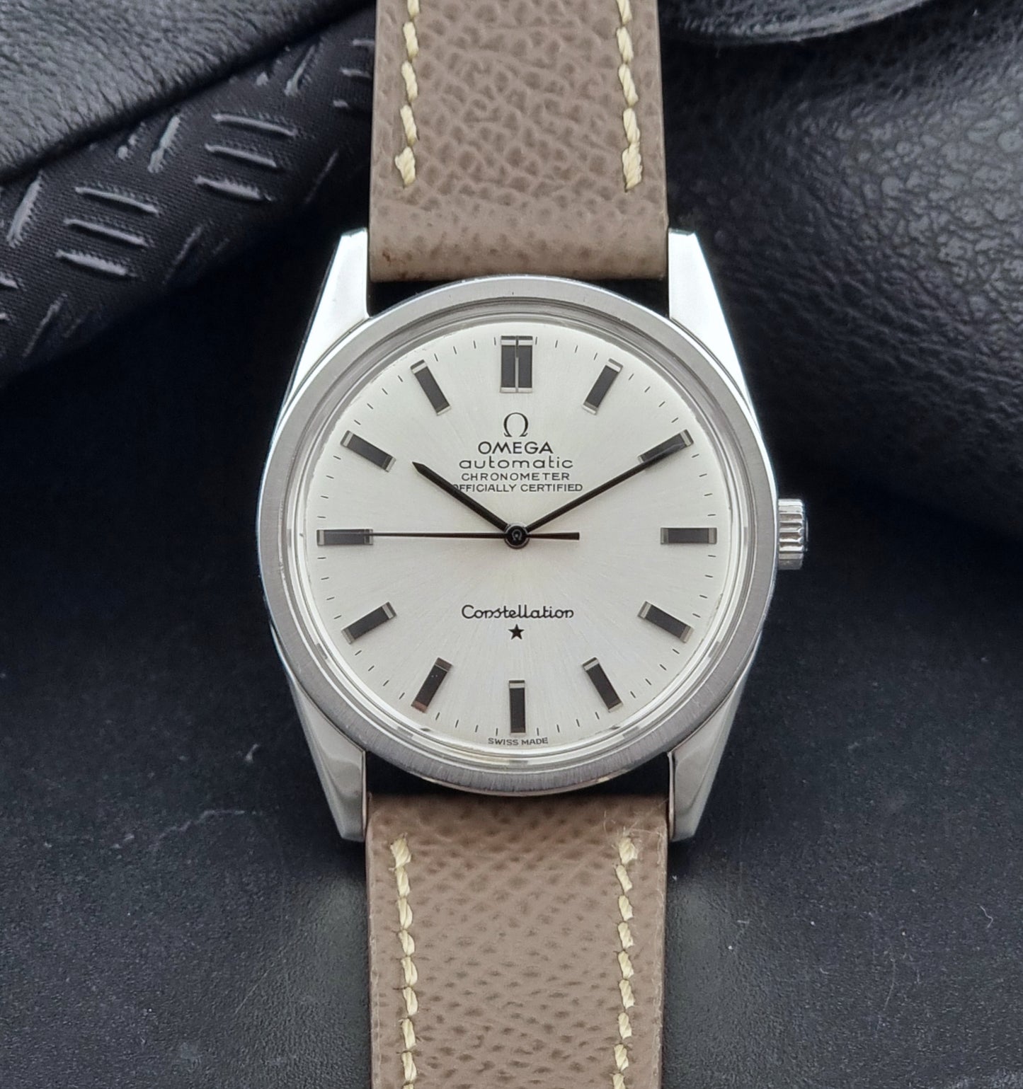 Vintage Omega watch Constellation 167.021 Chronometer with brown leather strap on a dark gray background dial view