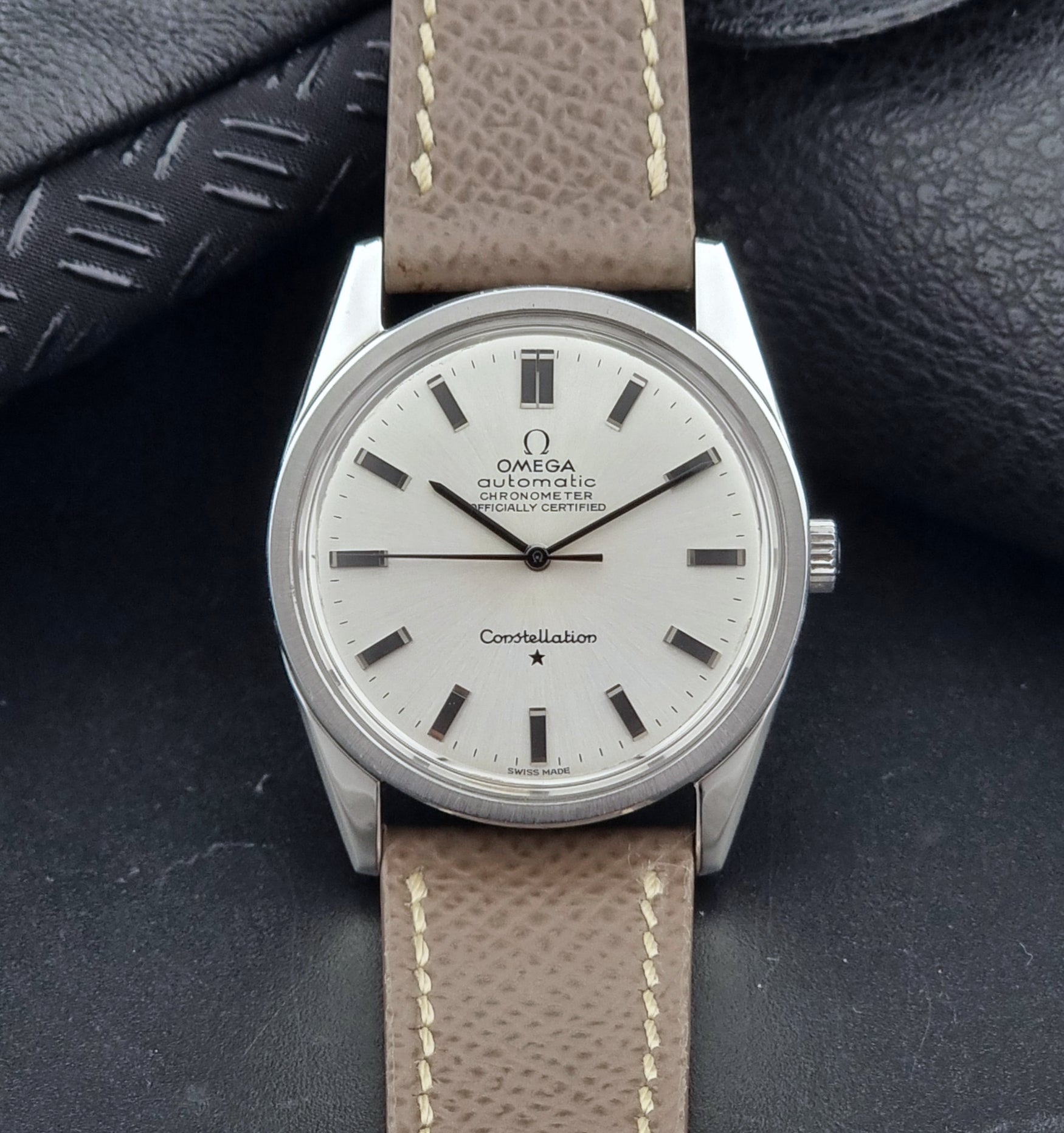 Vintage Omega watch Constellation 167.021 Chronometer with brown leather strap on a dark gray background dial view