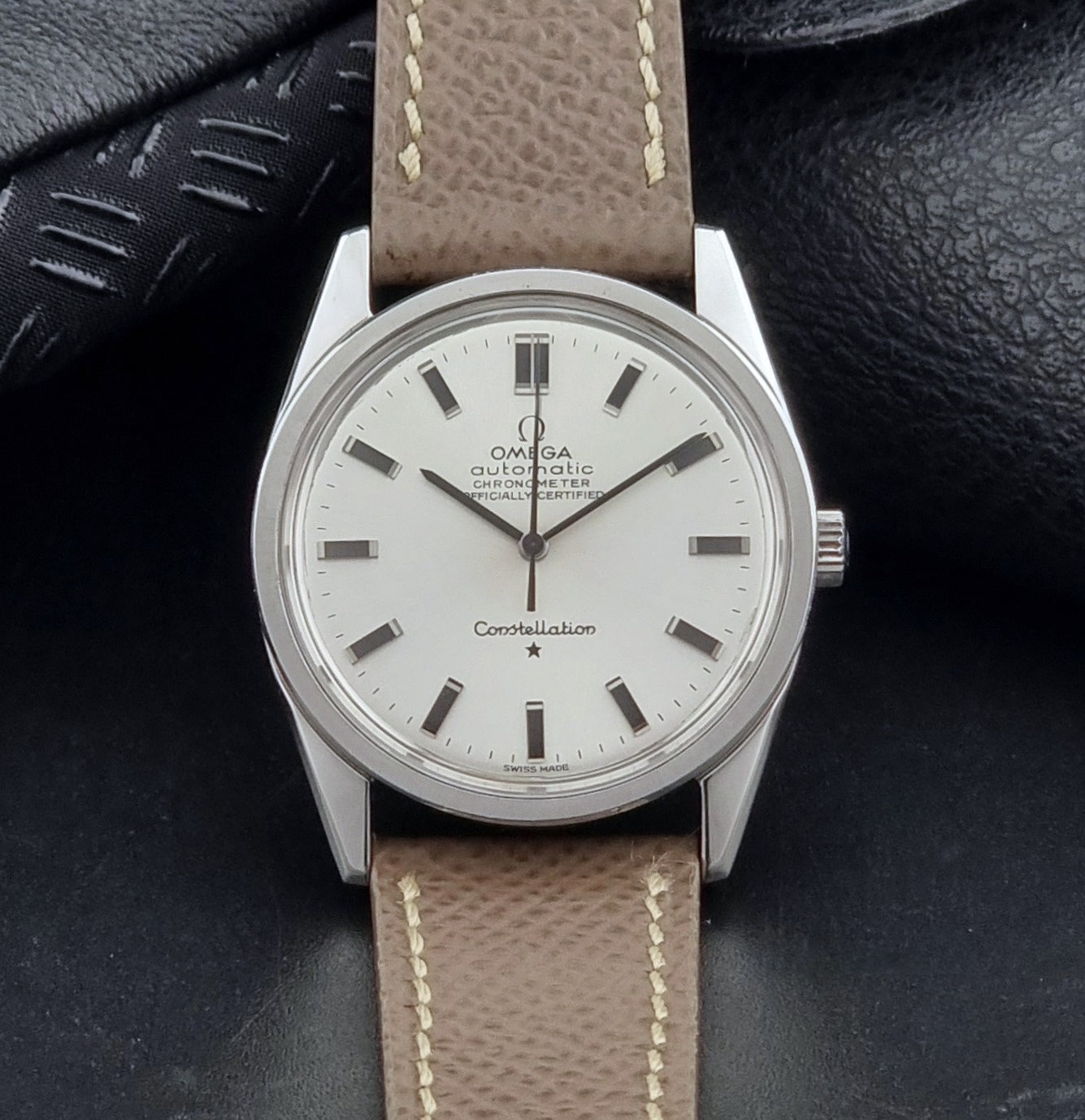 Vintage Omega watch Constellation 167.021 Chronometer with brown leather strap on a dark gray background front view