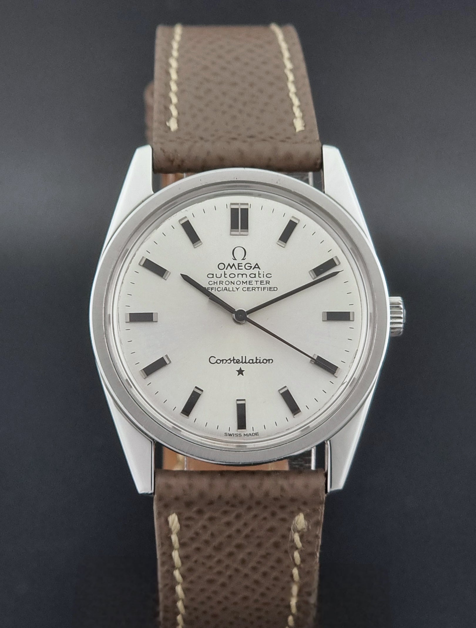 Vintage Omega watch Constellation 167.021 Chronometer with brown leather strap on a dark gray background close dial view