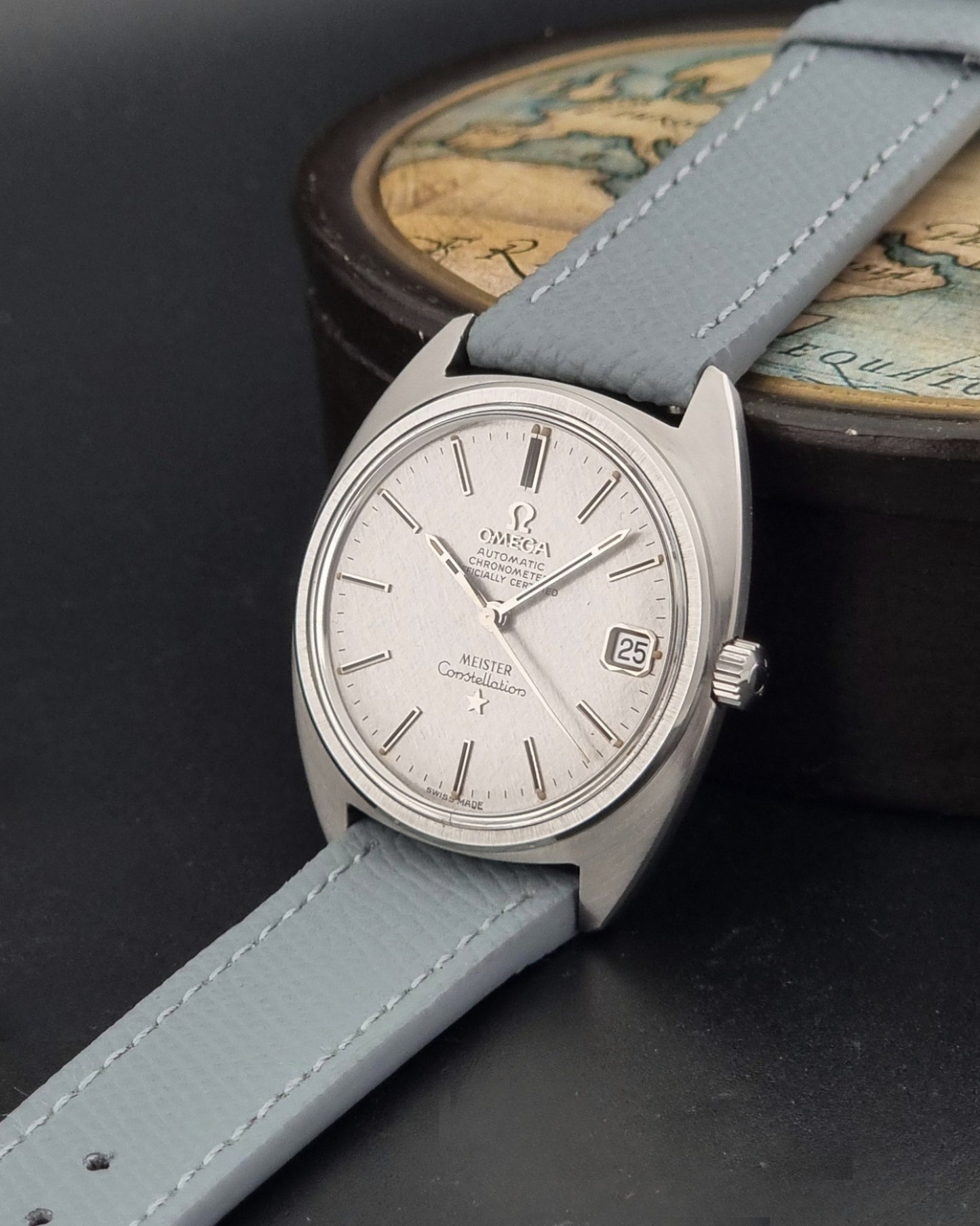 Vintage Omega Constellation 168.017 with a grey leather strap on a dark background crown view