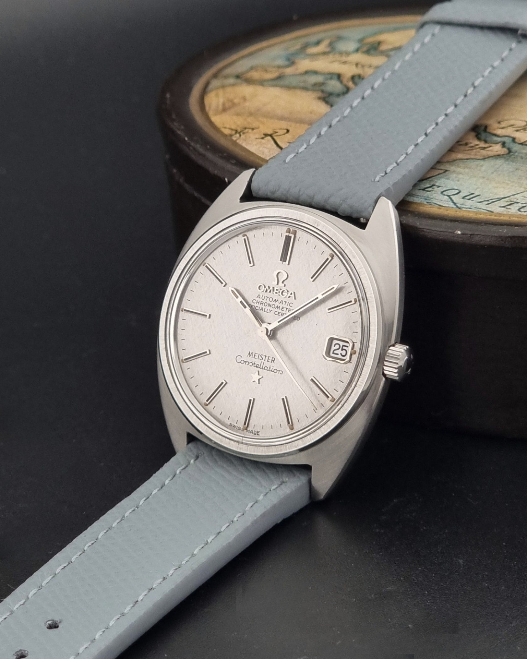 Vintage Omega Constellation 168.017 with a grey leather strap on a dark background crown view