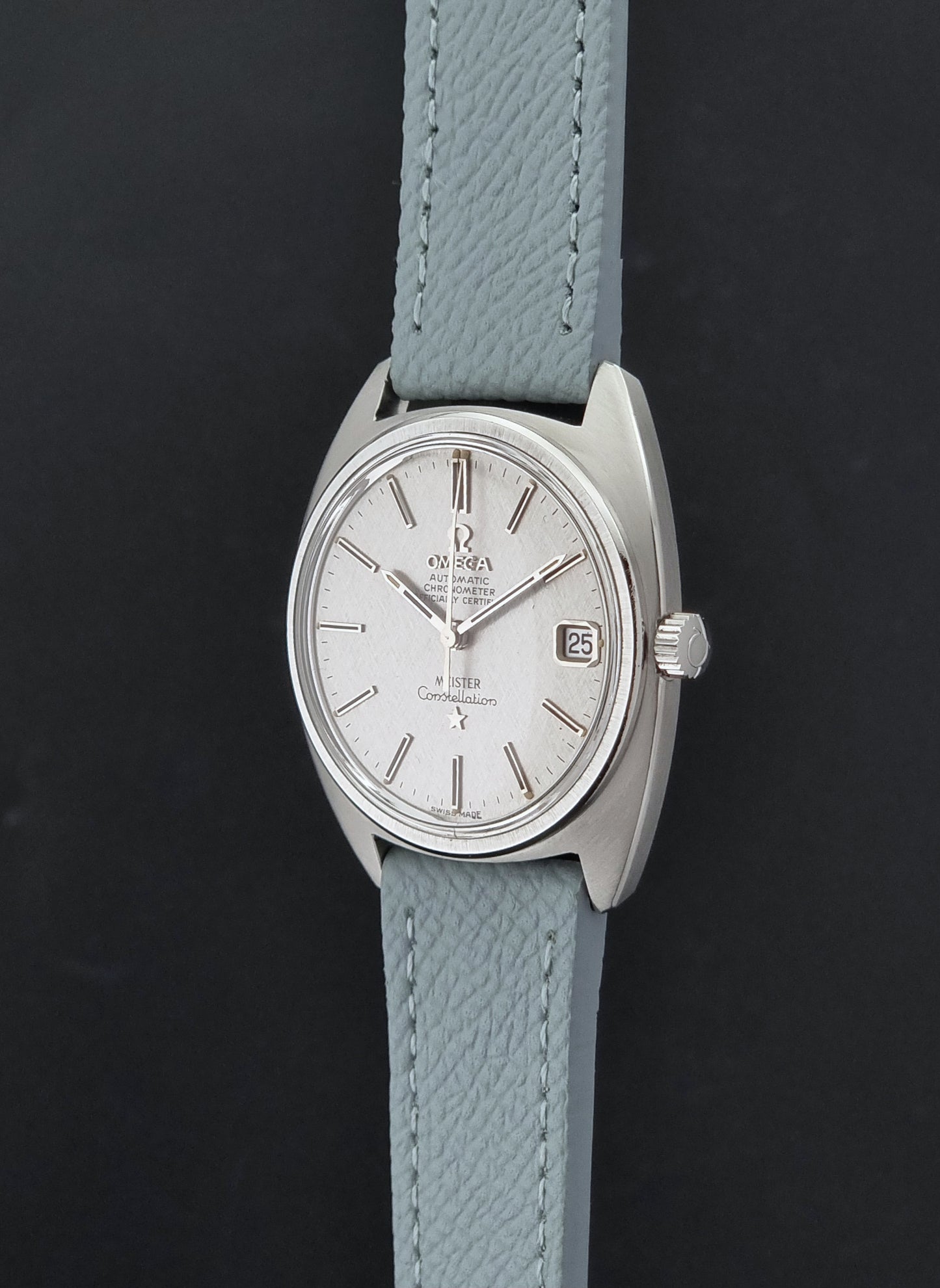 Vintage Omega Constellation 168.017 with a grey leather strap on a dark background crown profile view