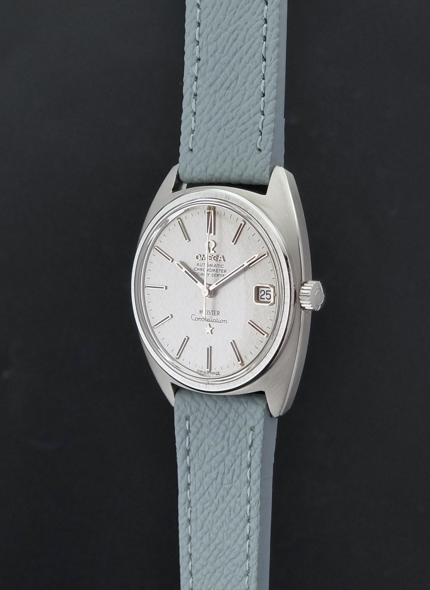 Vintage Omega Constellation 168.017 with a grey leather strap on a dark background crown profile view