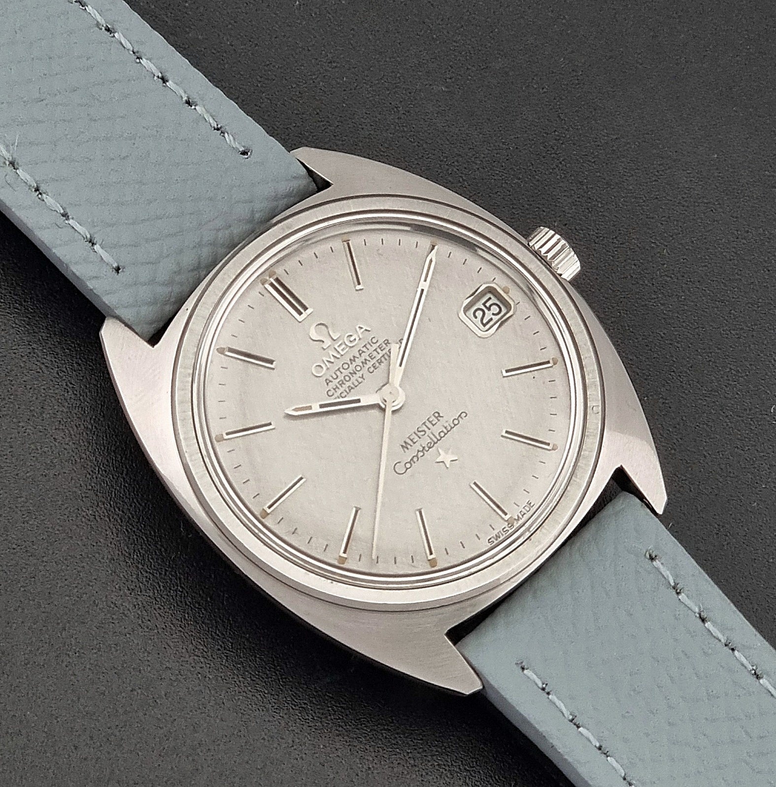 Vintage Omega Constellation 168.017 with a grey leather strap on a dark background close up dial view