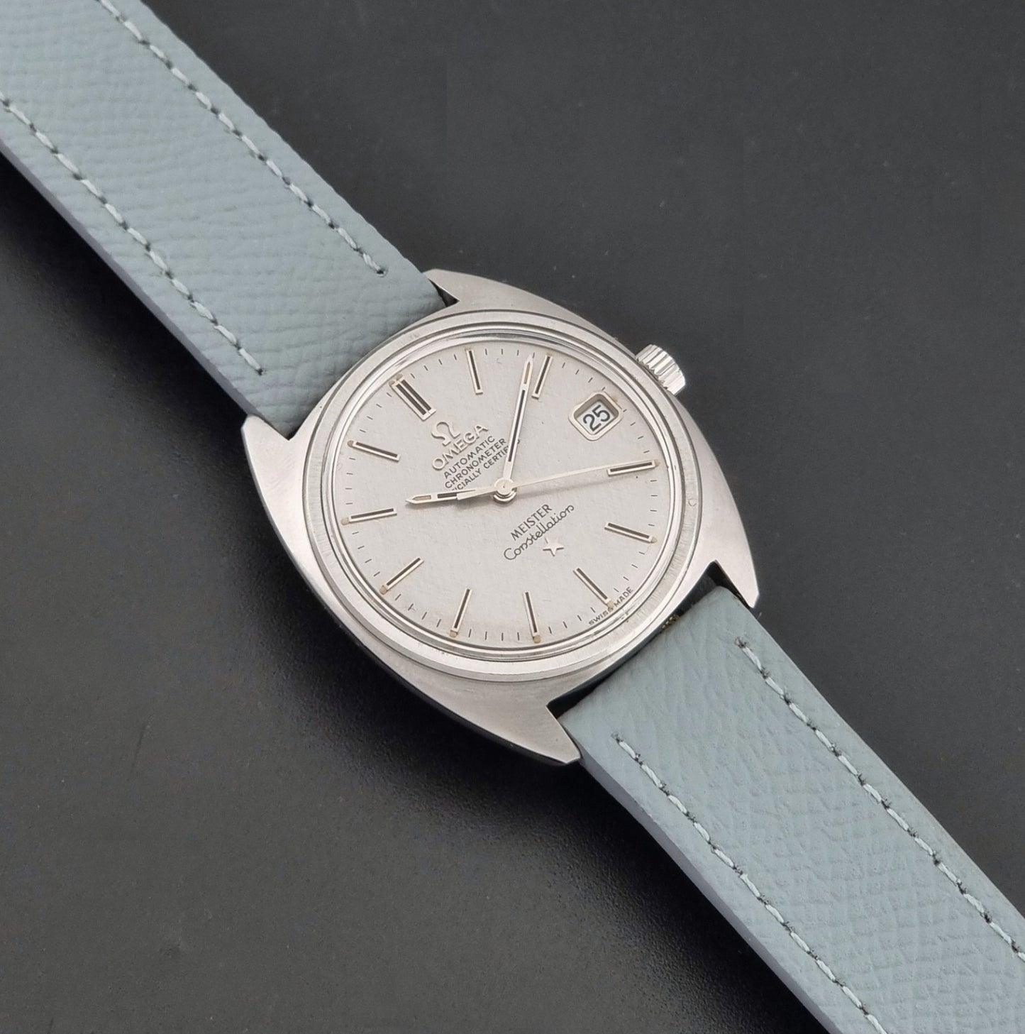 Vintage Omega Constellation 168.017 with a grey leather strap on a dark background dial