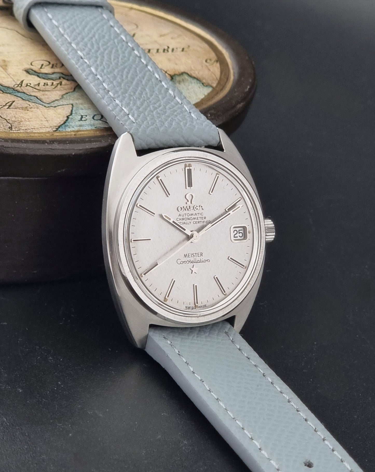 Vintage Omega Constellation 168.017 with a grey leather strap on a dark background side view