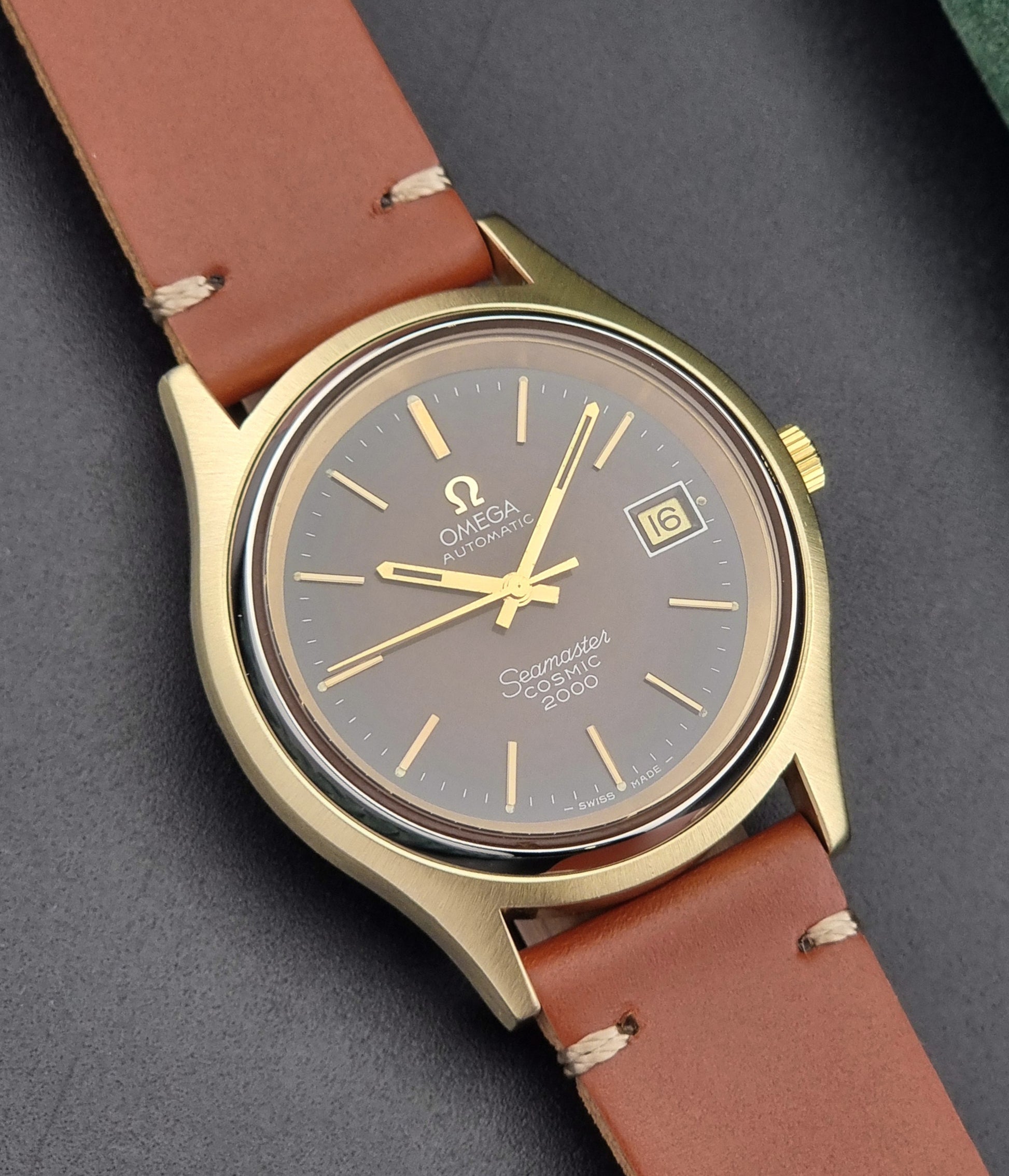 Vintage Omega Seamaster Cosmic 2000 Gold watch with brown leather strap on a dark background