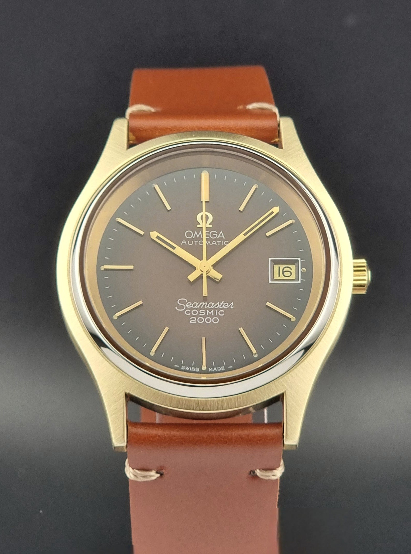 Vintage Omega Seamaster Cosmic 2000 Gold watch with brown leather strap on a dark background