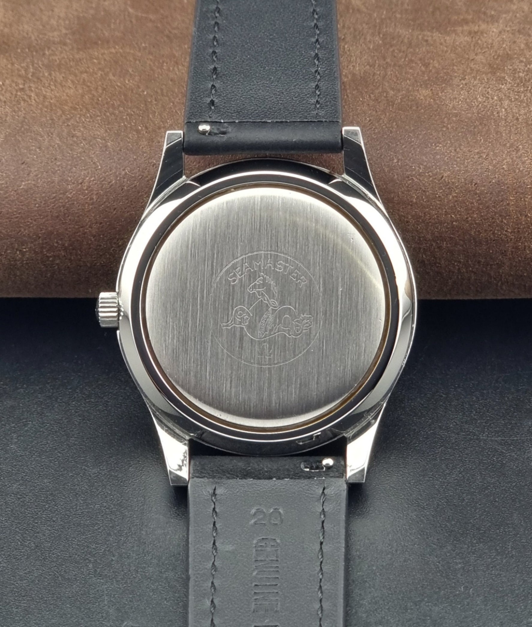 Vintage Omega Wristwatch Seamaster Cosmic 2000 Jumbo 166.128 grey dial with black leather strap on a dark gray background case back view