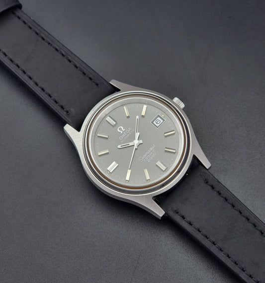 Vintage Omega Wristwatch Seamaster Cosmic 2000 Jumbo 166.128 grey dial with black leather strap on a dark gray background dial