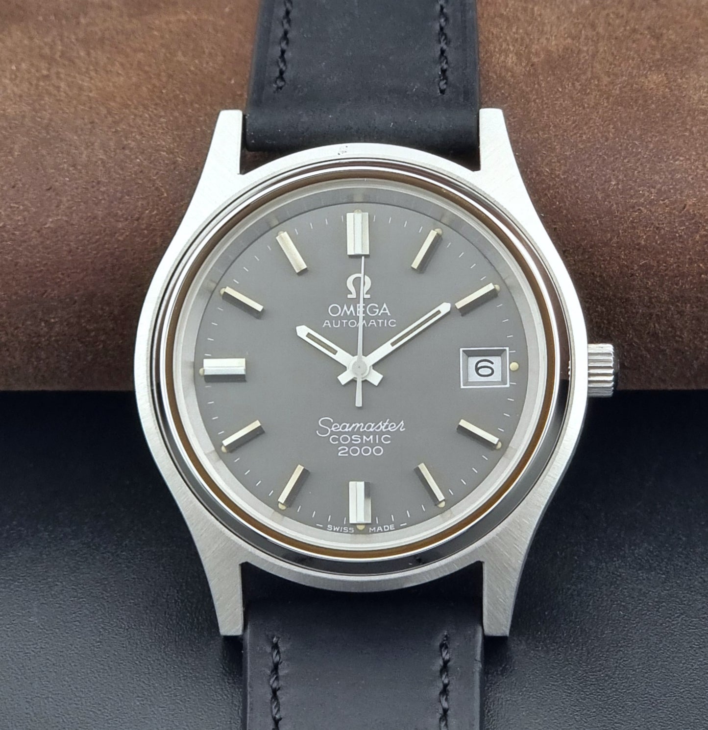 Vintage Omega Wristwatch Seamaster Cosmic 2000 Jumbo 166.128 grey dial with black leather strap on a dark gray background dial view