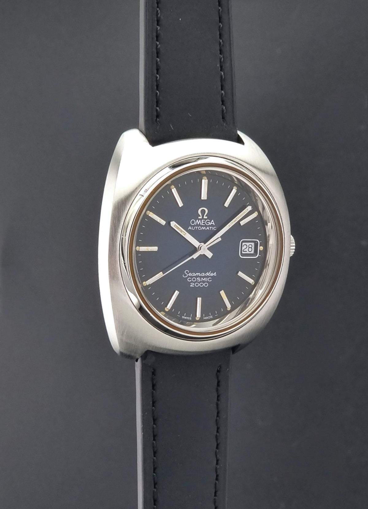 Vintage Omega Wristwatch 166.132 Seamaster Cosmic 2000 with a silver-tone metal case, dark blue dial, and black leather strap, shown against a dark gray background.